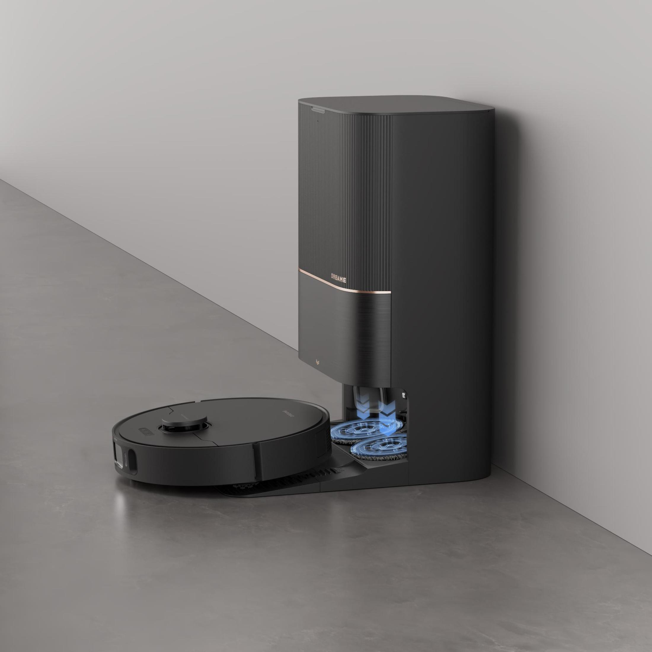 Czarny robot odkurzający obok stacji ładowania i czyszczenia. Szara podłoga.