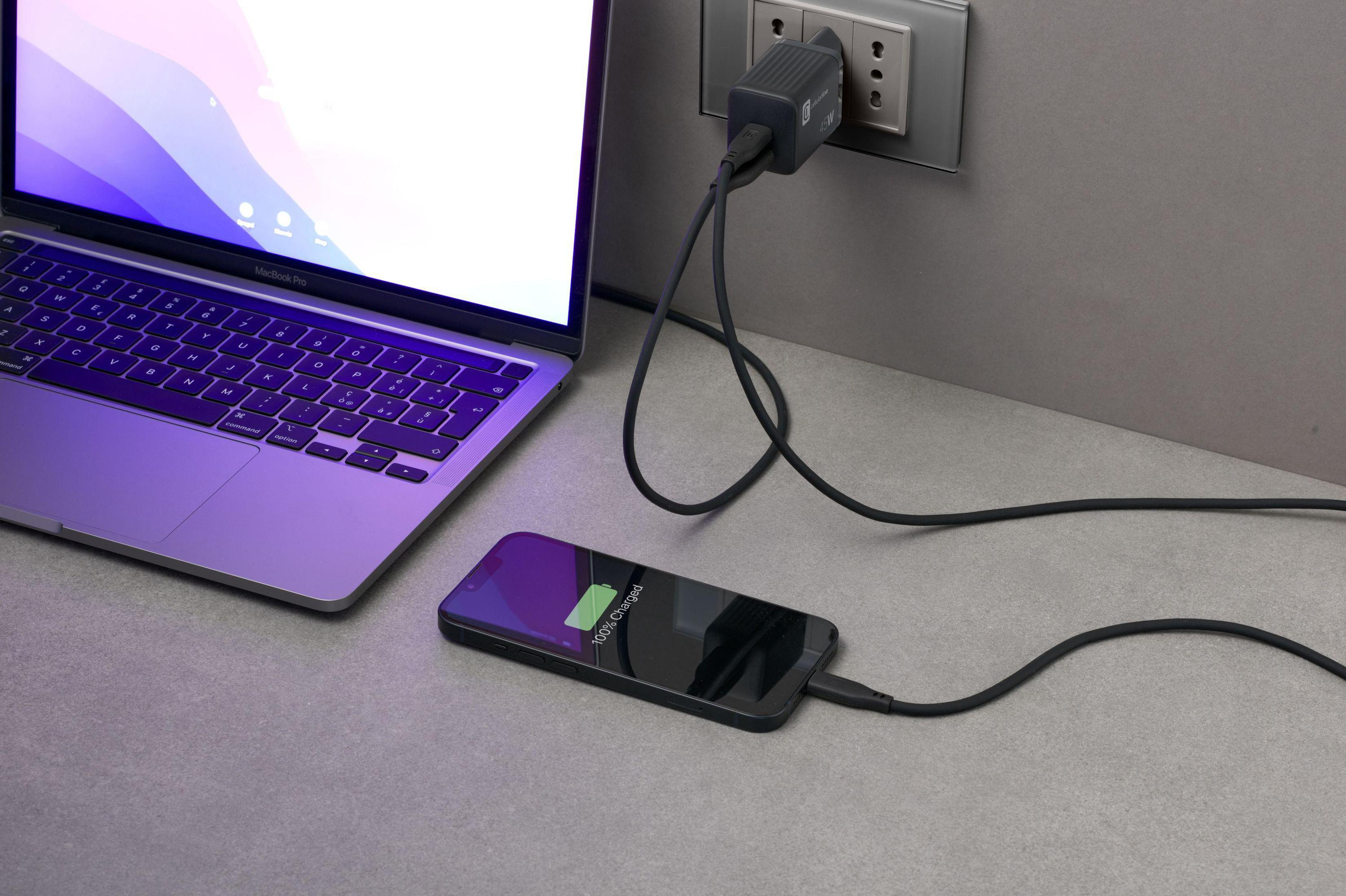Laptop e telefono in carica. Il telefono mostra '100% Carica'. Caricatore a muro.