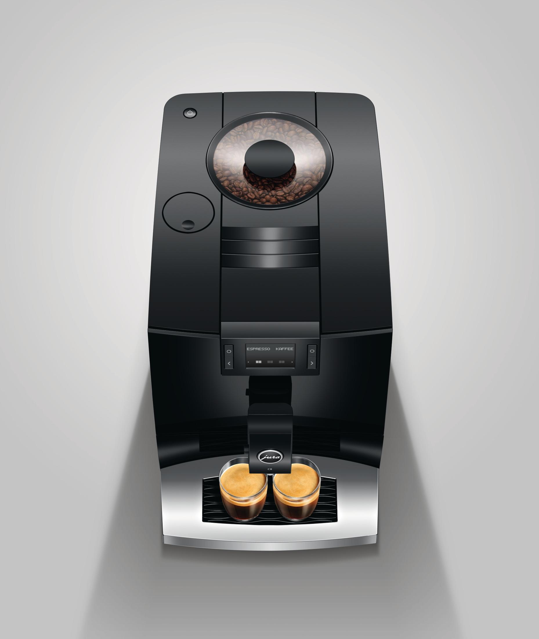 Czarny ekspres do kawy Jura z ziarnami kawy i dwoma espresso.
