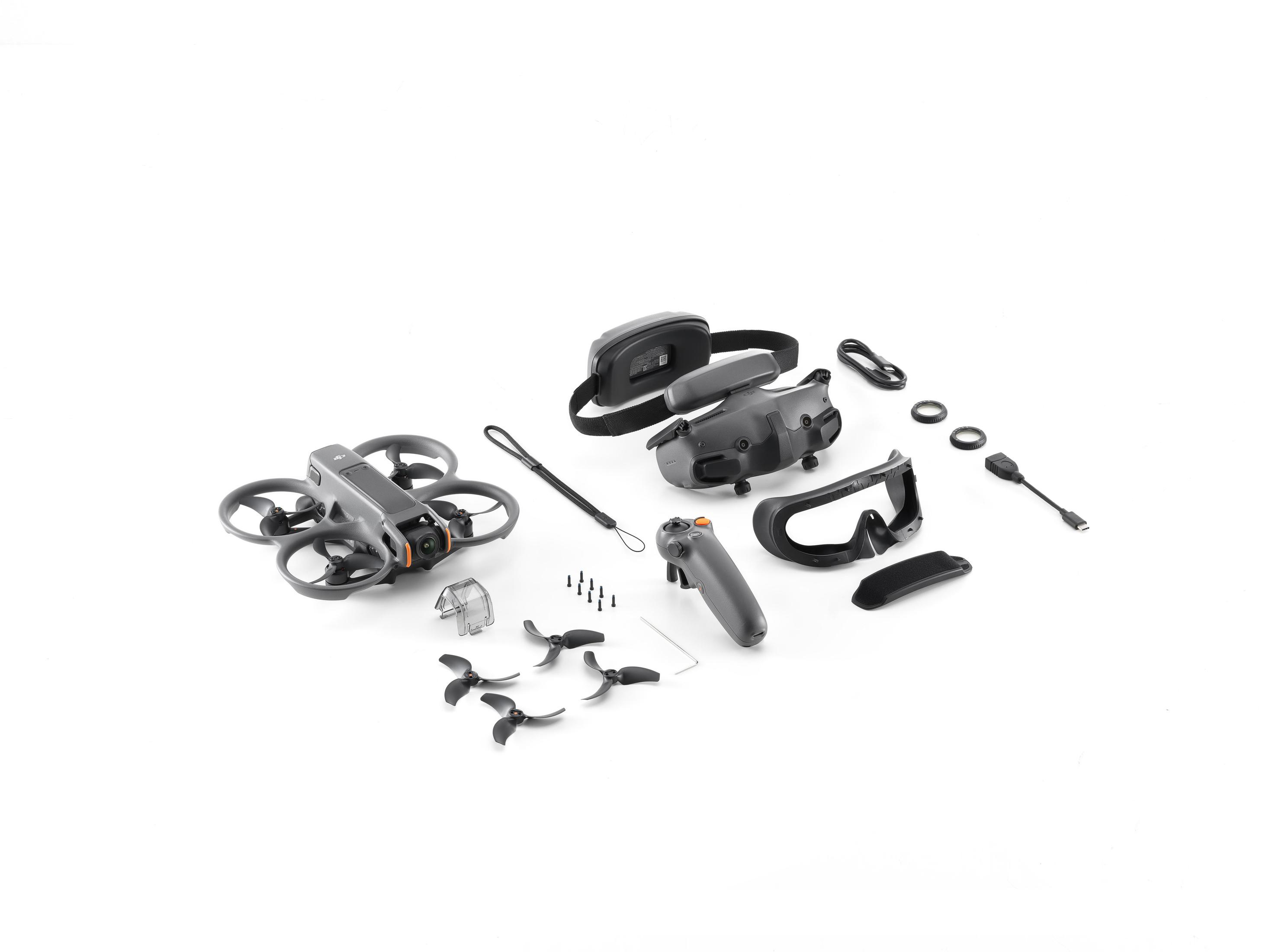 Een drone, afstandsbediening, bril en accessoires op een wit oppervlak.