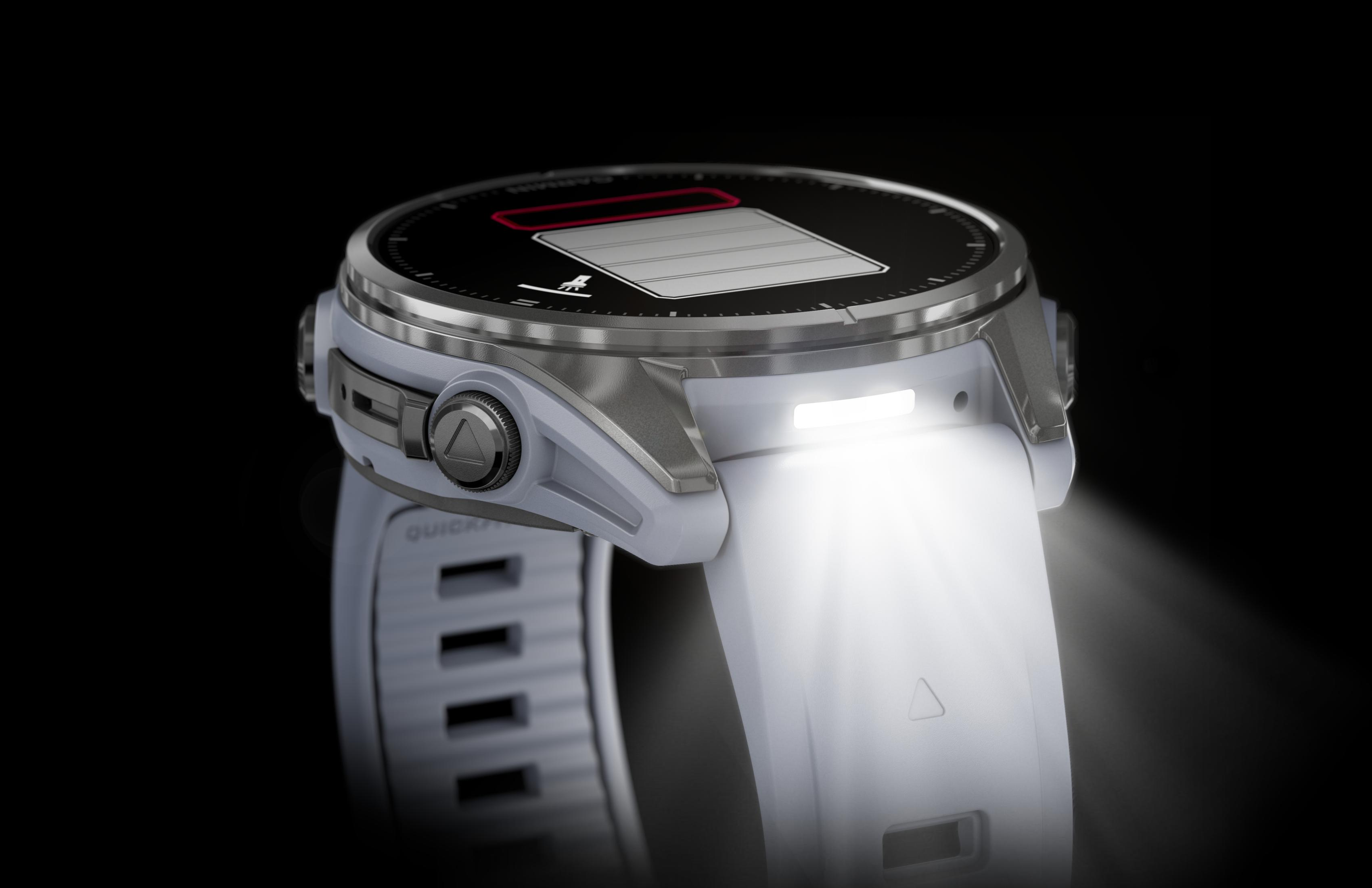 Biały smartwatch Garmin ze światłem, pokazujący czarny ekran z ikoną baterii.