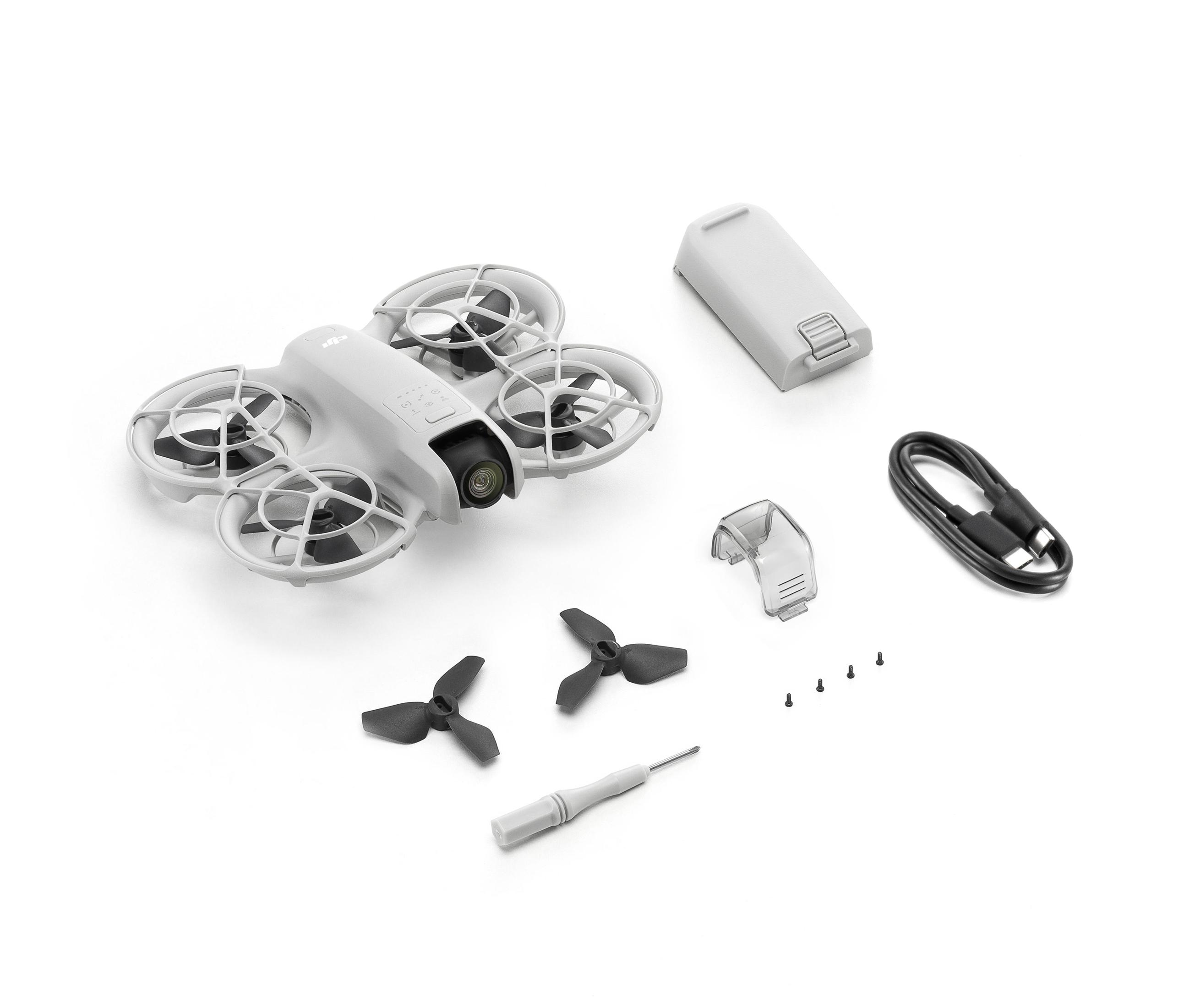 Eine graue Drohne mit Propellern, Akku, USB-Kabel und Zubehör auf Weiß.