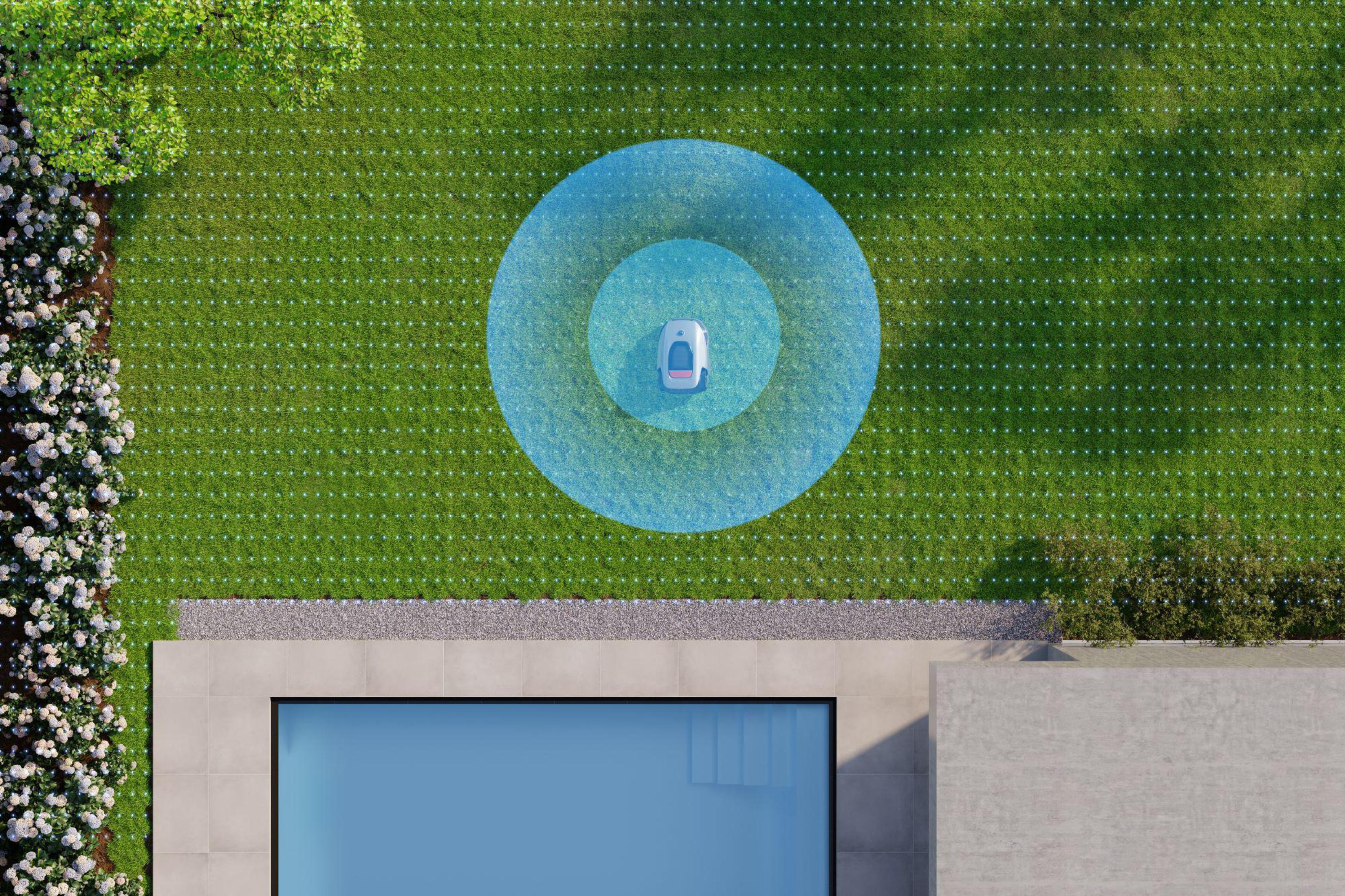 Robotyczna kosiarka do trawy kosząca trawnik, w niebieskiej, okrągłej granicy. Basen w tle.