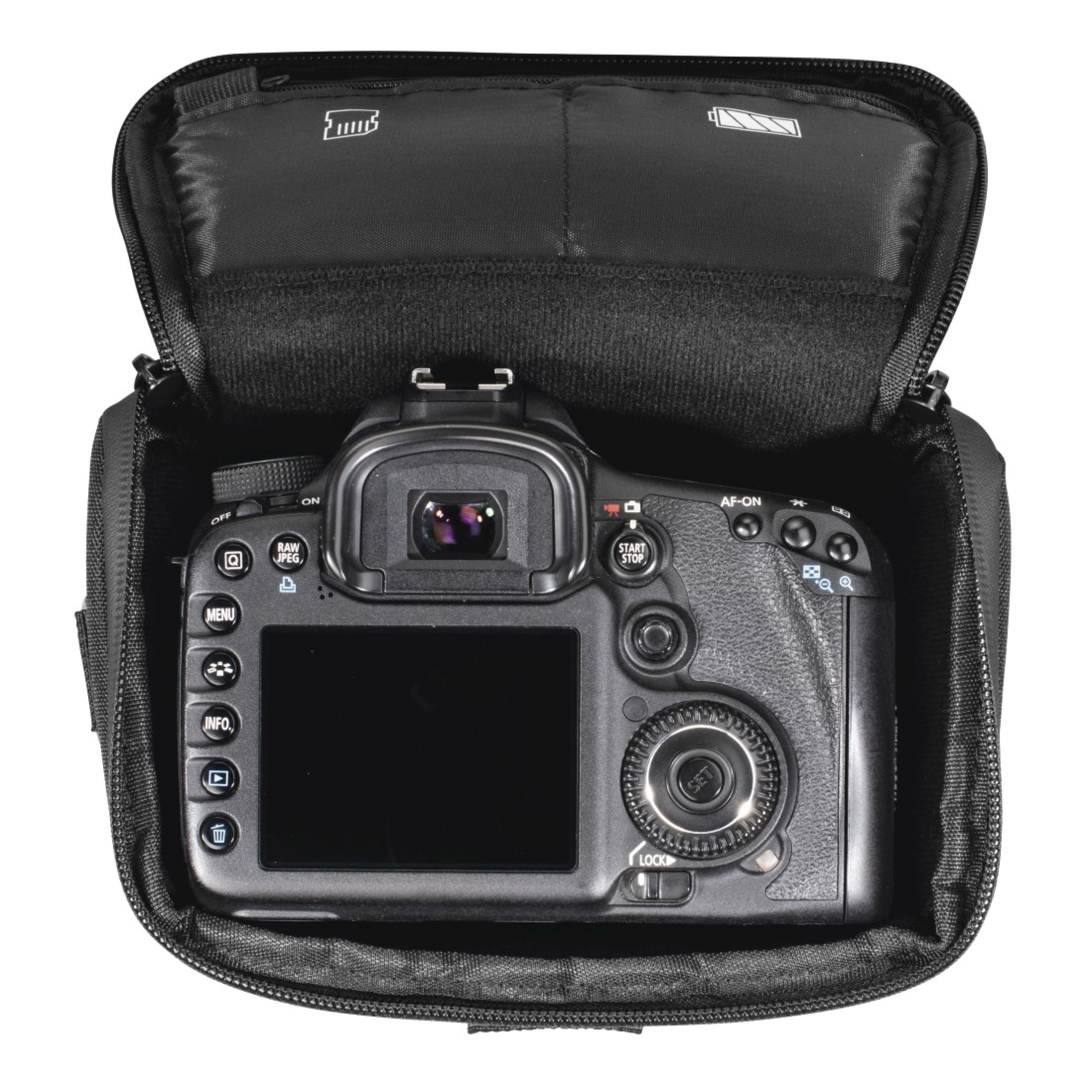 Schwarze Kamera in einer schwarzen Tasche. Die Kamera ist offen, dem Betrachter zugewandt. Weißer Hintergrund.