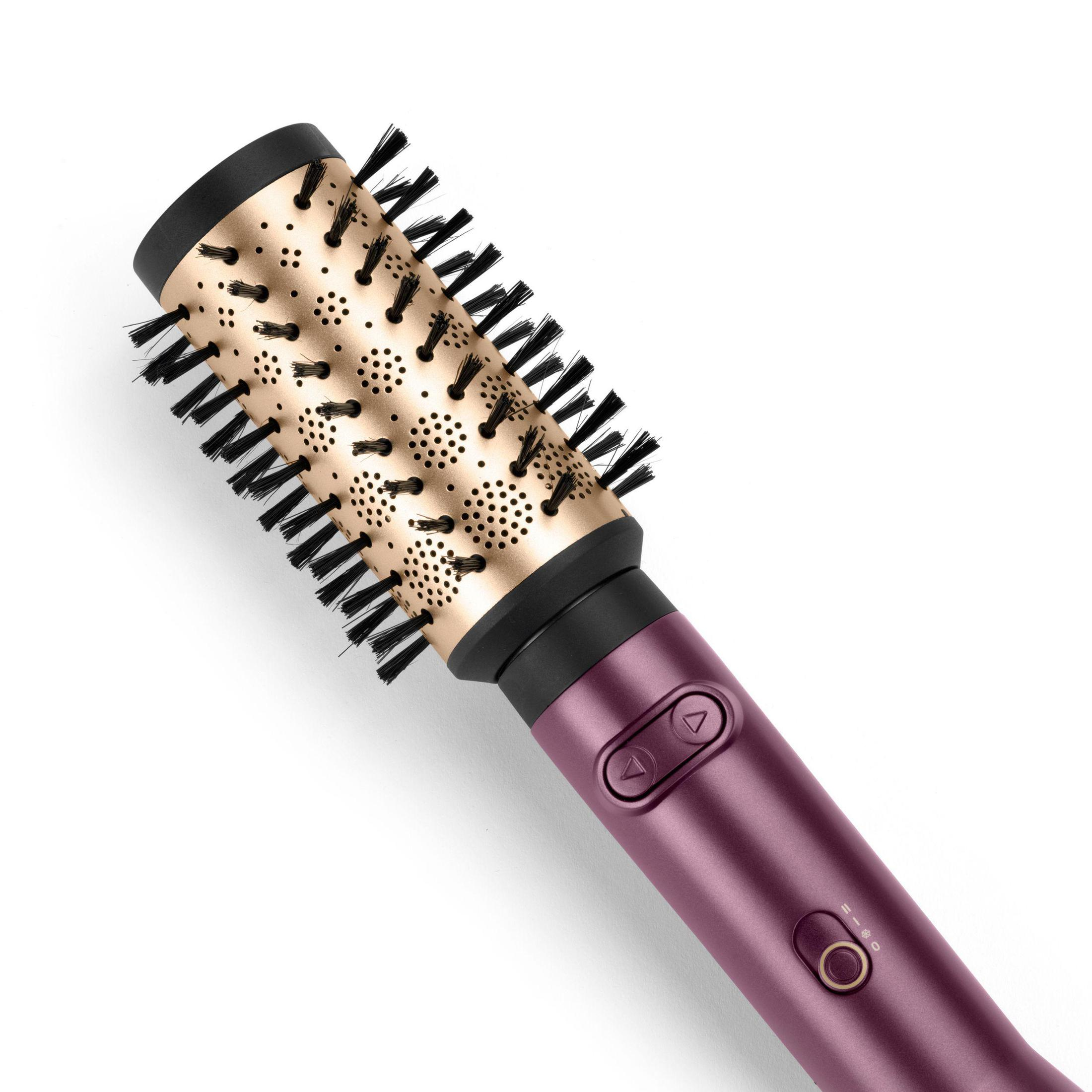 Fioletowo-złota szczotka do włosów z czarnym włosiem. Okrągły kształt z przyciskami. Białe tło. Widok z góry.