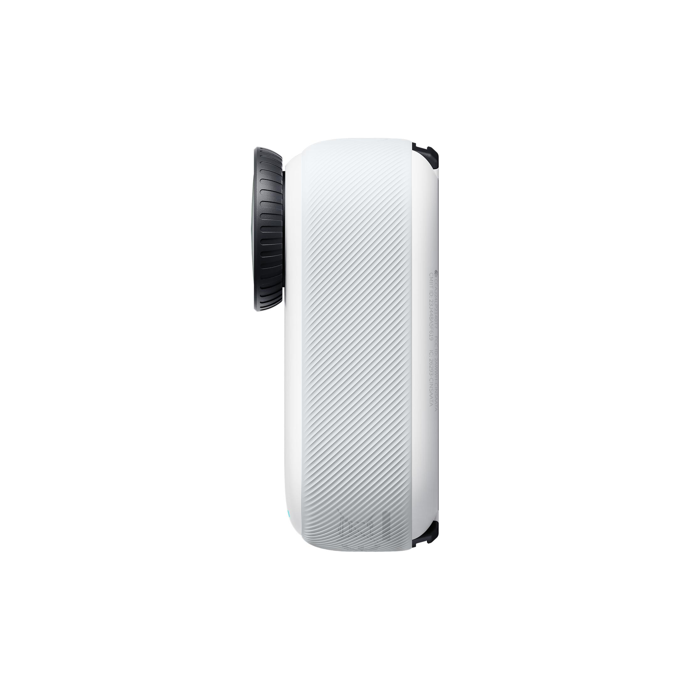 Biały, boczny profil małego aparatu. Czarny obiektyw z przodu, z żebrowanym uchwytem. Białe tło.