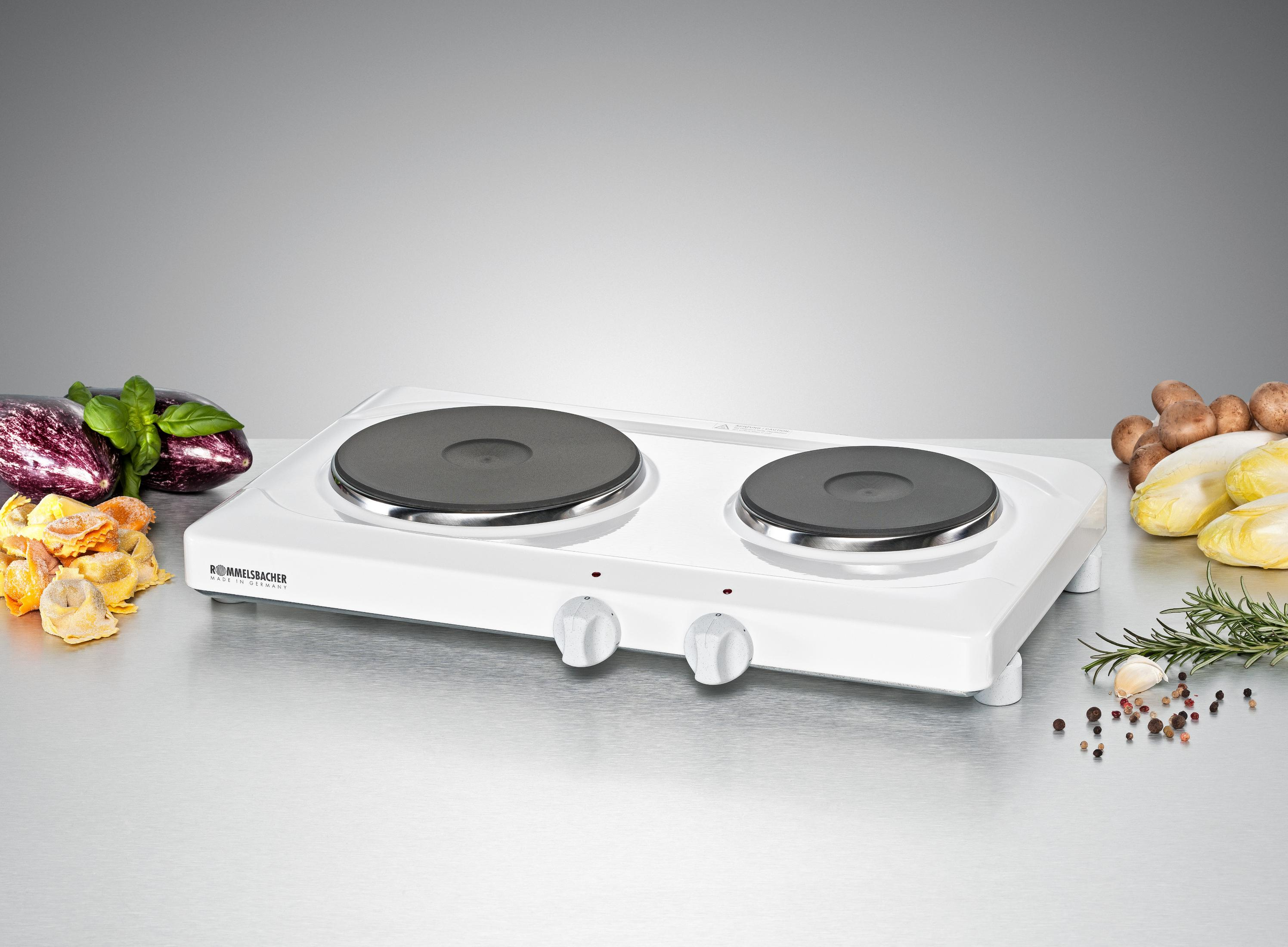 Biała podwójna płyta grzewcza z dwiema powierzchniami grzewczymi i pokrętłami sterowania, ze składnikami.