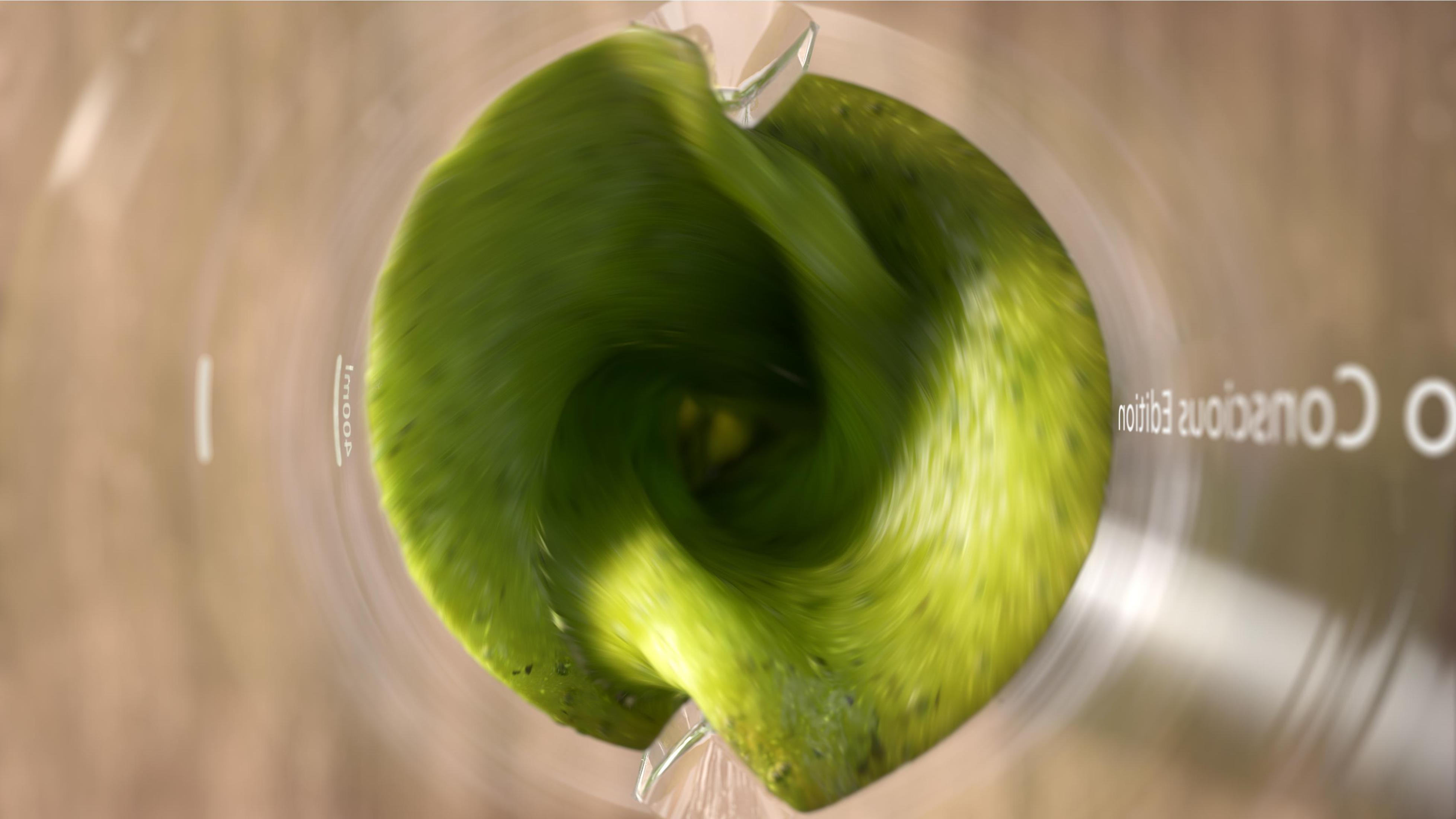Grüner Smoothie wird in einem Mixer gemixt. Draufsicht, verschwommener Hintergrund, hellgrüne Farbe.