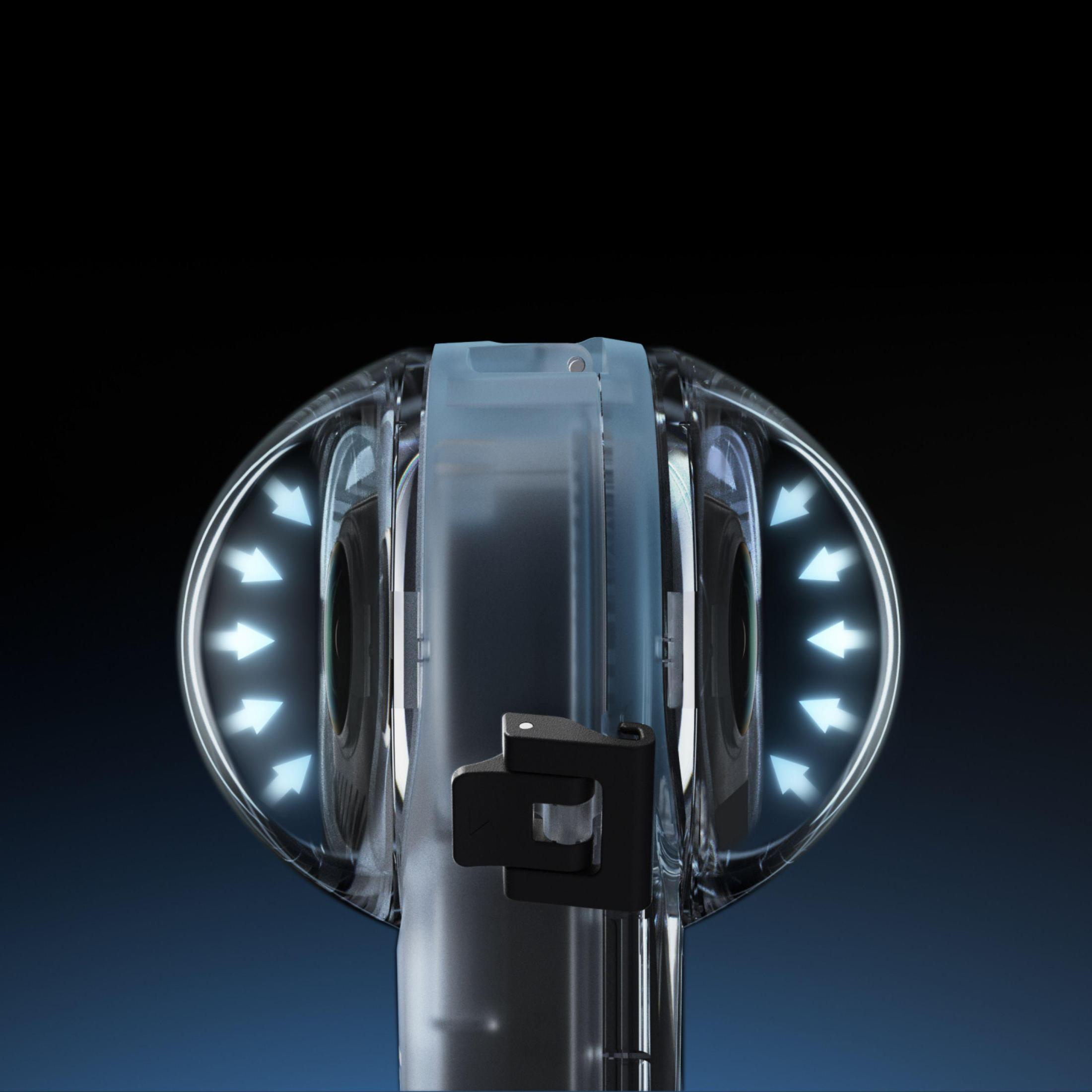 Zbliżenie przezroczystego urządzenia ze strzałkami i czarnym tłem. Urządzenie ma soczewkę.