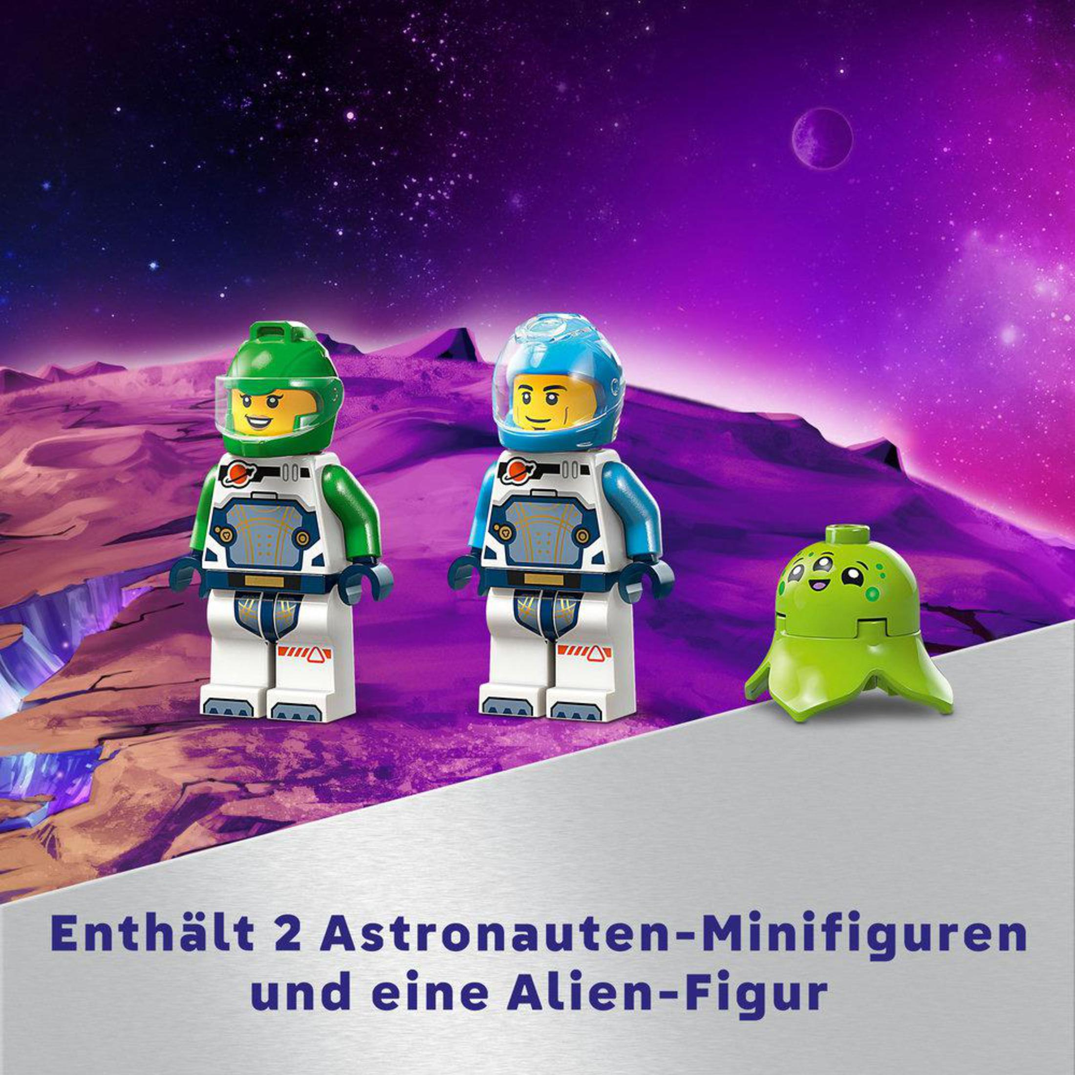 Dwie figurki Lego astronautów i zielona zabawka obcego przed fioletową sceną kosmiczną.