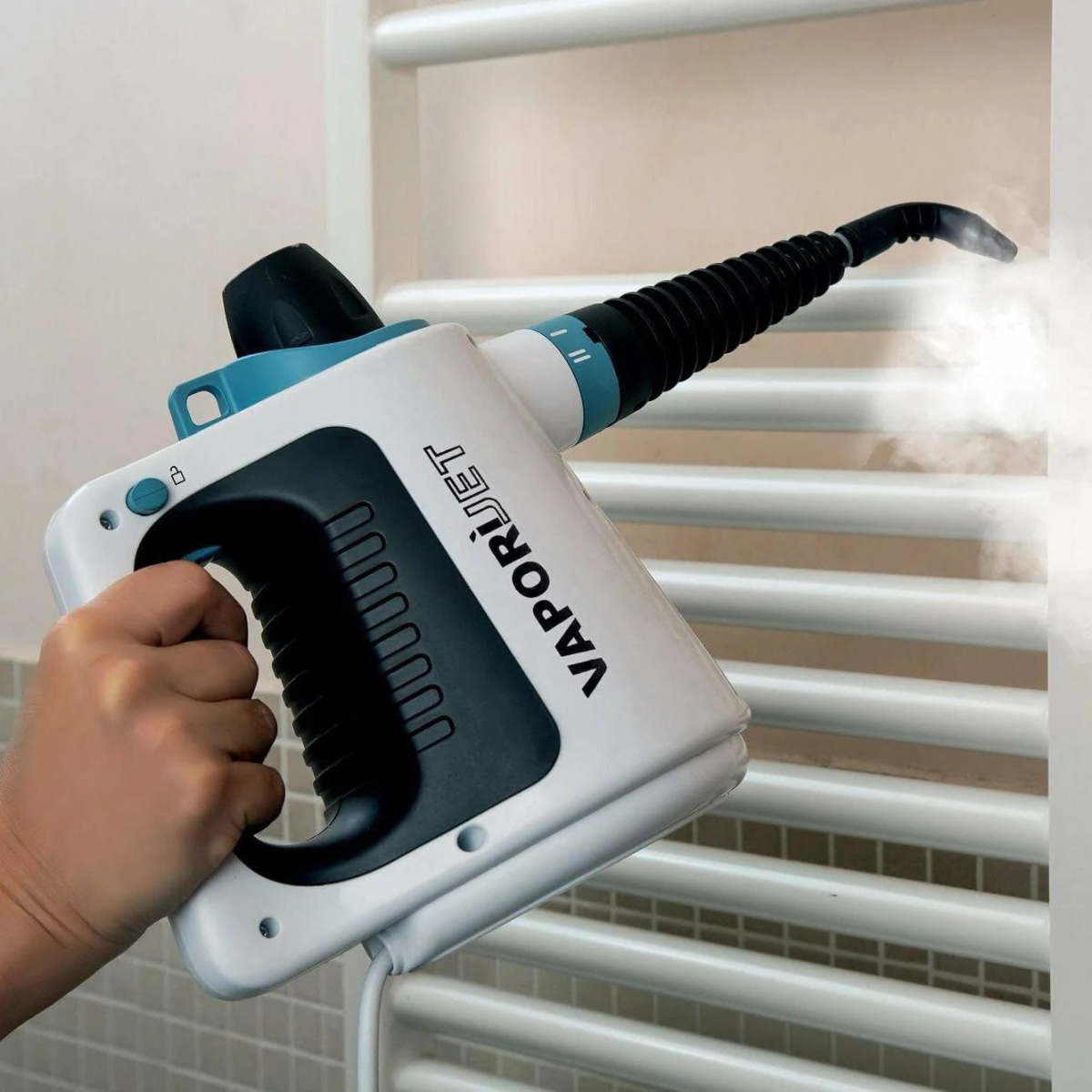 Biała i turkusowa ręczna myjka parowa służy do czyszczenia parą białego kaloryfera.