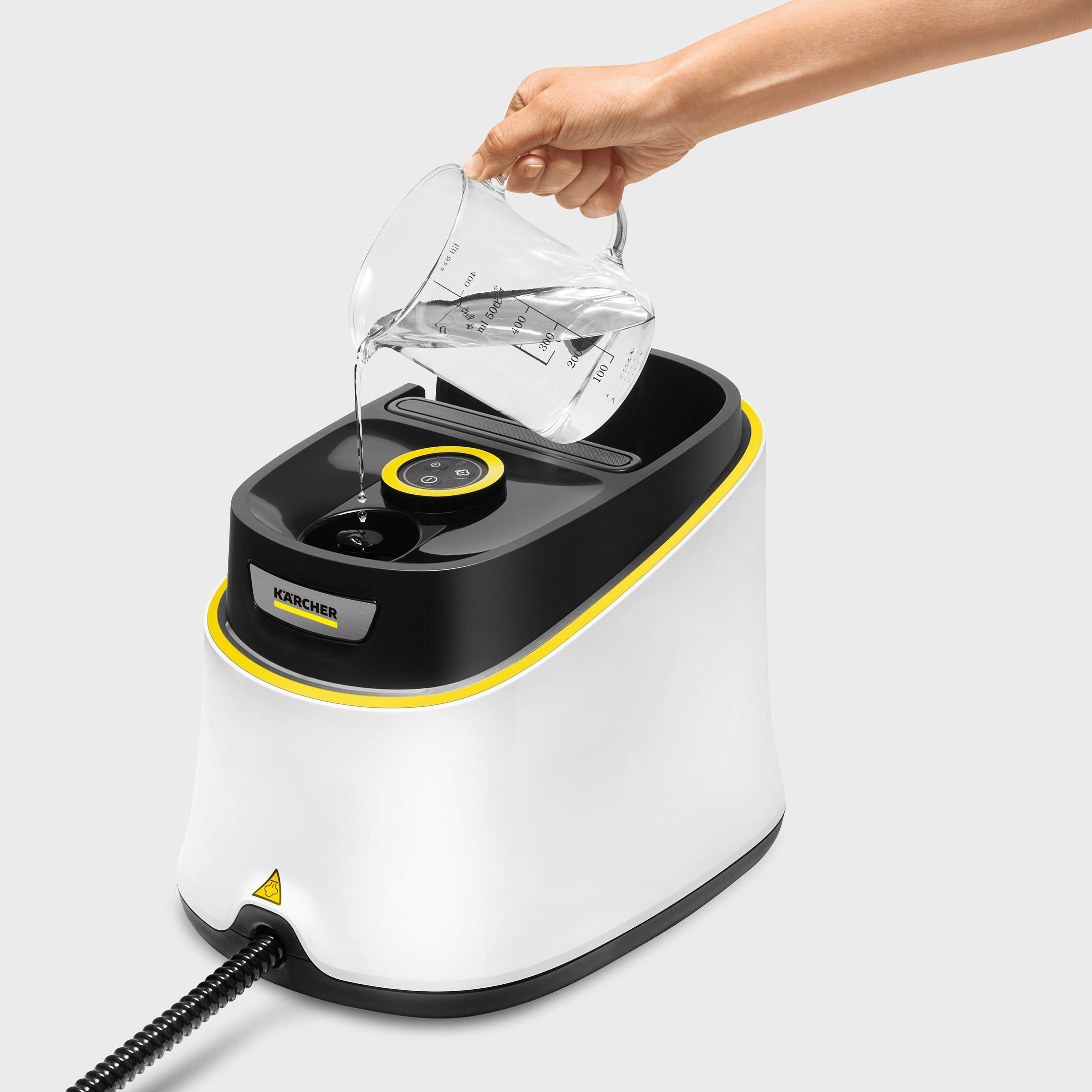 Osoba wlewa wodę do myjki parowej.