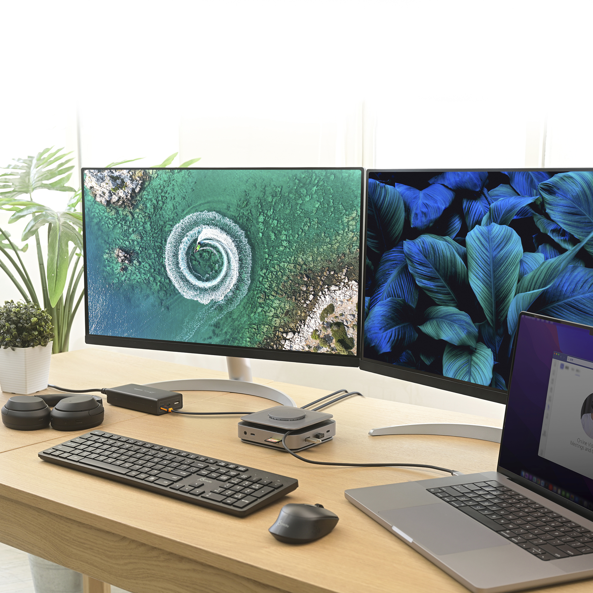 Deux moniteurs, un clavier, une souris et un ordinateur portable sont sur un bureau en bois.