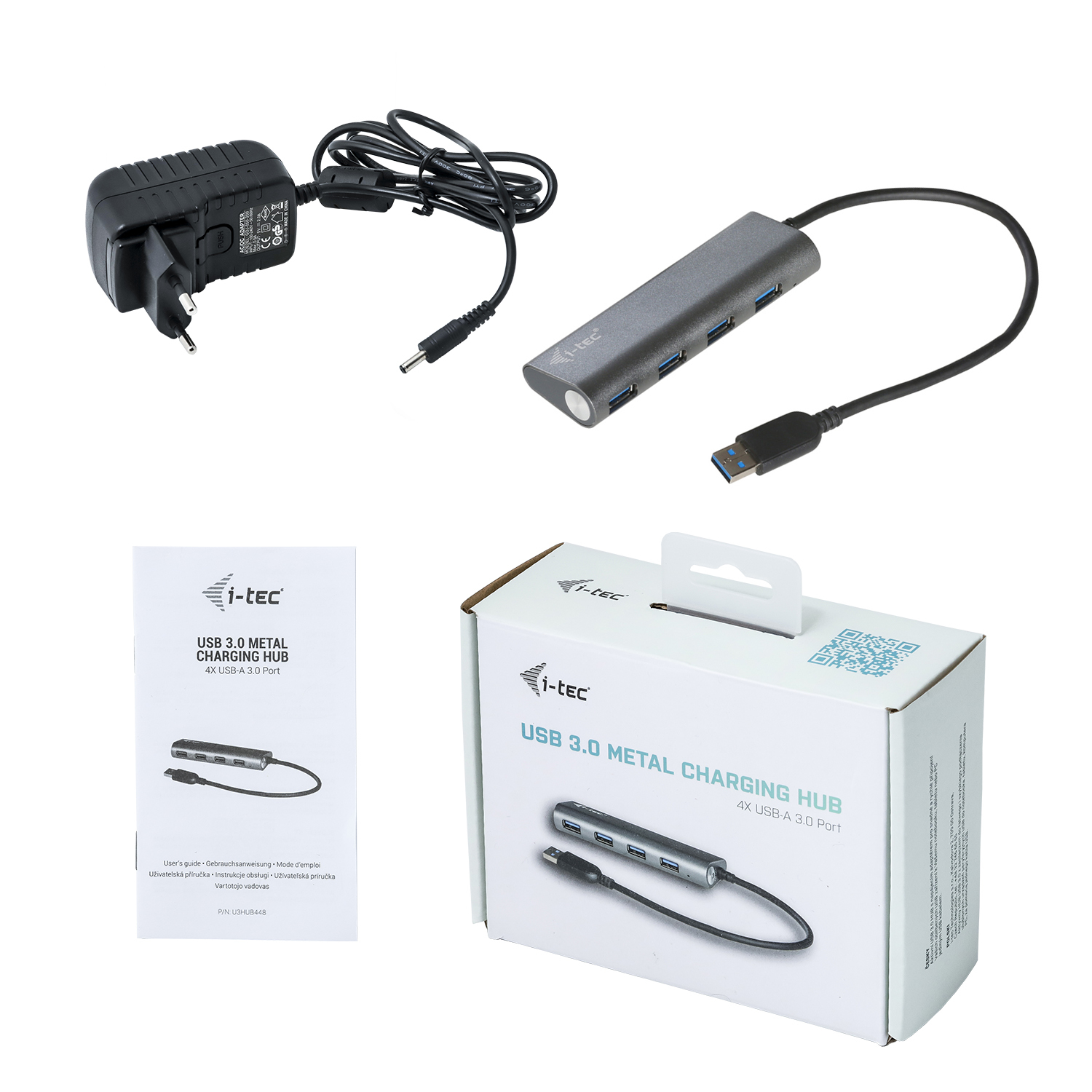 Hub USB, chargeur et manuel sur blanc. Le hub est gris avec un câble noir. Le chargeur est noir. Le manuel est blanc.