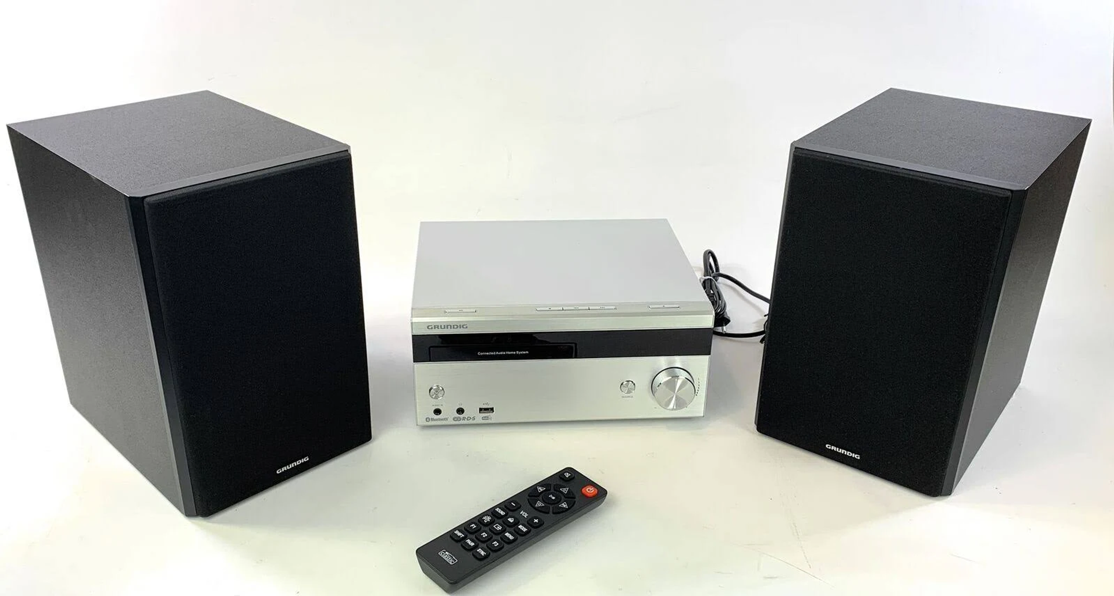 Grundig Stereoanlage mit Lautsprechern und Fernbedienung. Silbernes Hauptgerät.