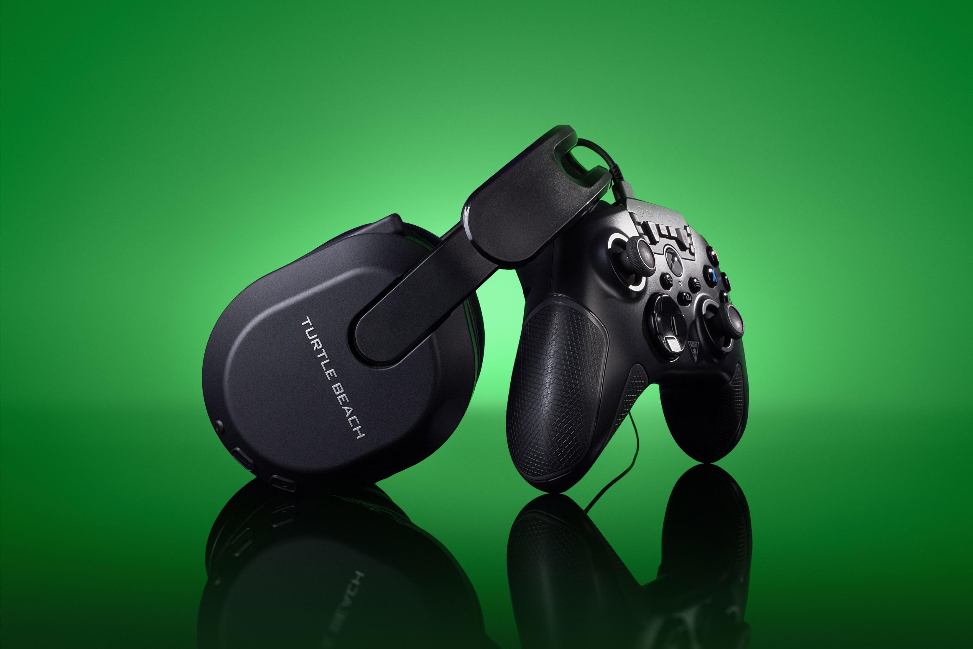 Czarne słuchawki i kontroler na zielonym tle; powierzchnia odbijająca.