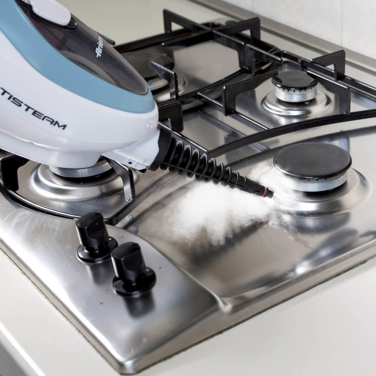 Czyszczenie parą ze stali nierdzewnej płyty kuchennej za pomocą ręcznego urządzenia do czyszczenia parą.