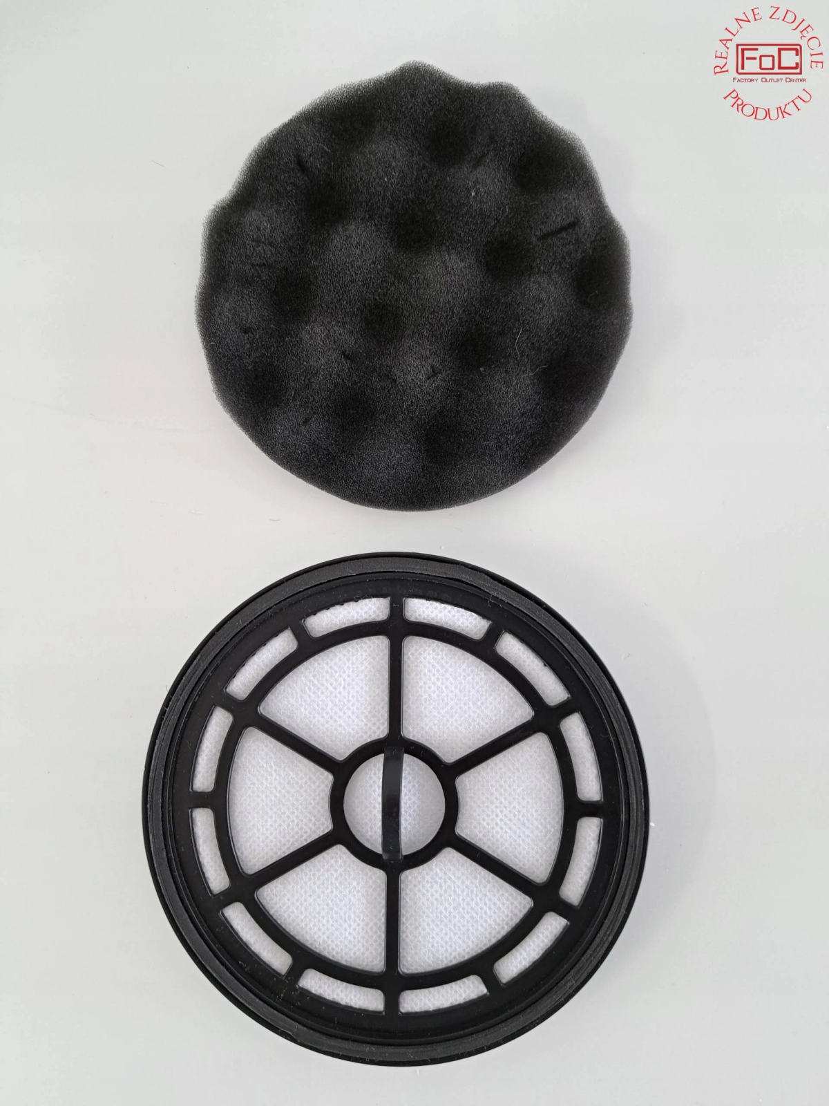 Dwa filtry powietrza. Jeden okrągły z czarną ramką i białym filtrem. Drugi to pianka.