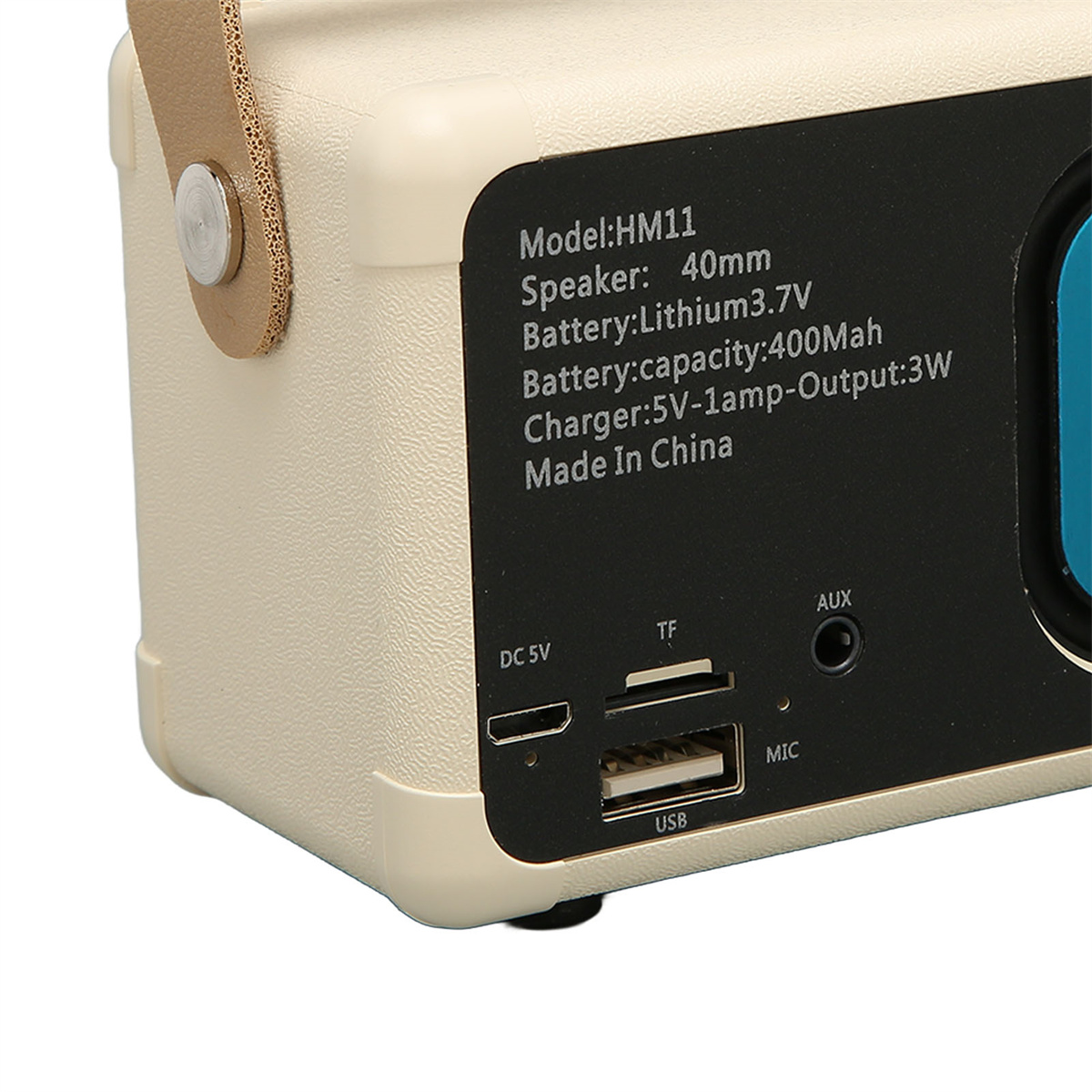 Kleiner beigefarbener Lautsprecher. Zeigt USB-, AUX- und DC-Eingänge. Text auf dem Lautsprecher. Weißer Hintergrund.