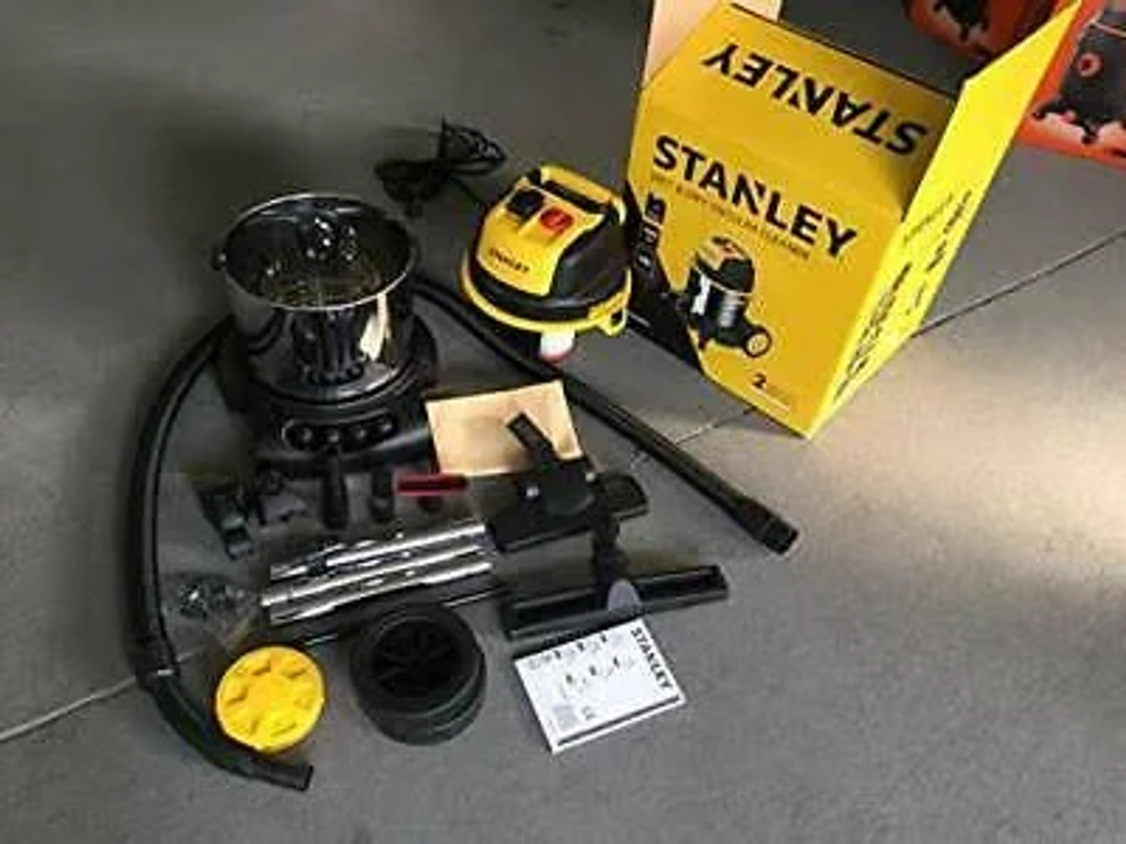Parti di aspirapolvere Stanley gialle. Un aspirapolvere giallo e le sue parti sparse.