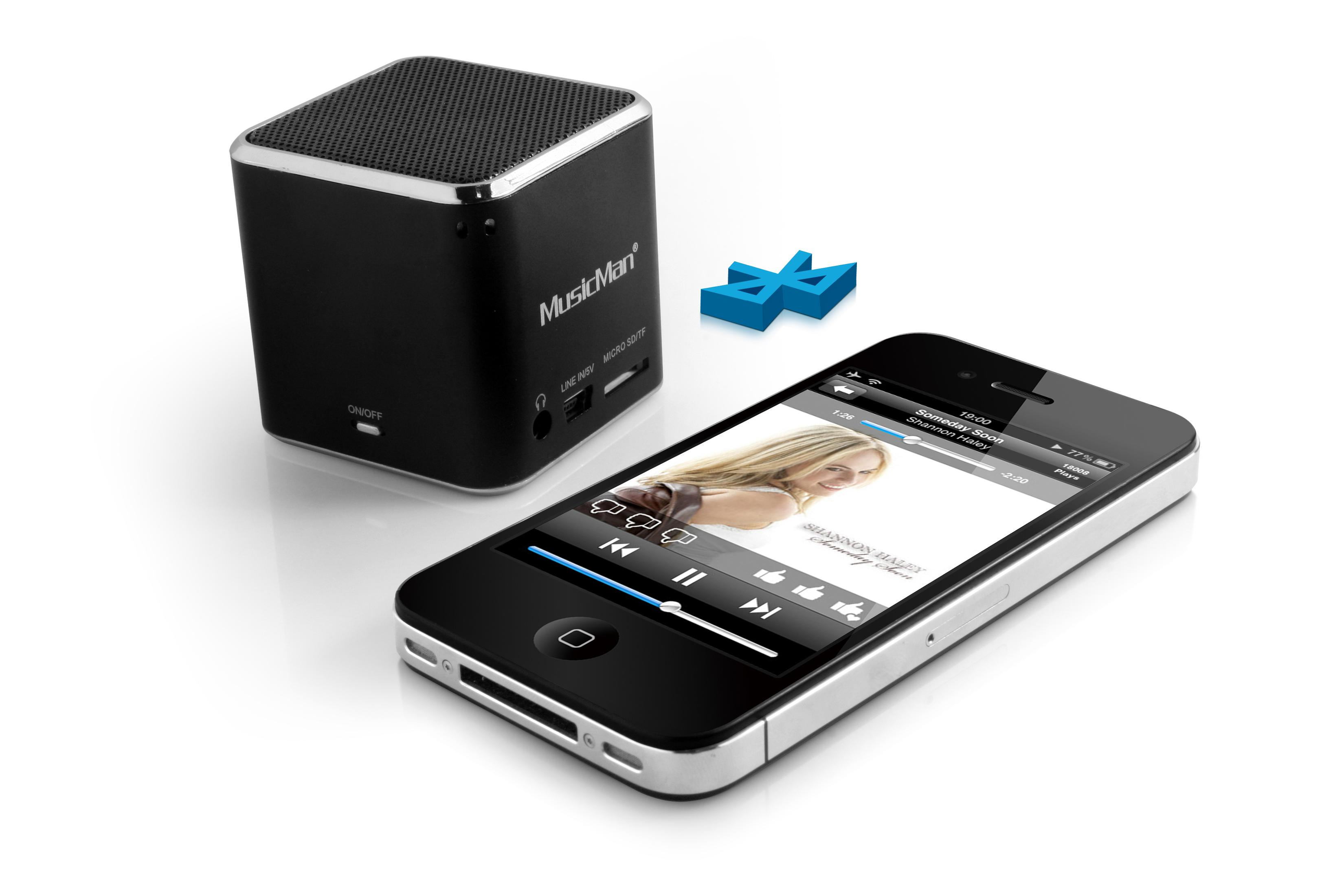 Czarny głośnik i telefon. Telefon pokazuje aplikację muzyczną z odtwarzanym utworem. Symbol Bluetooth widoczny.