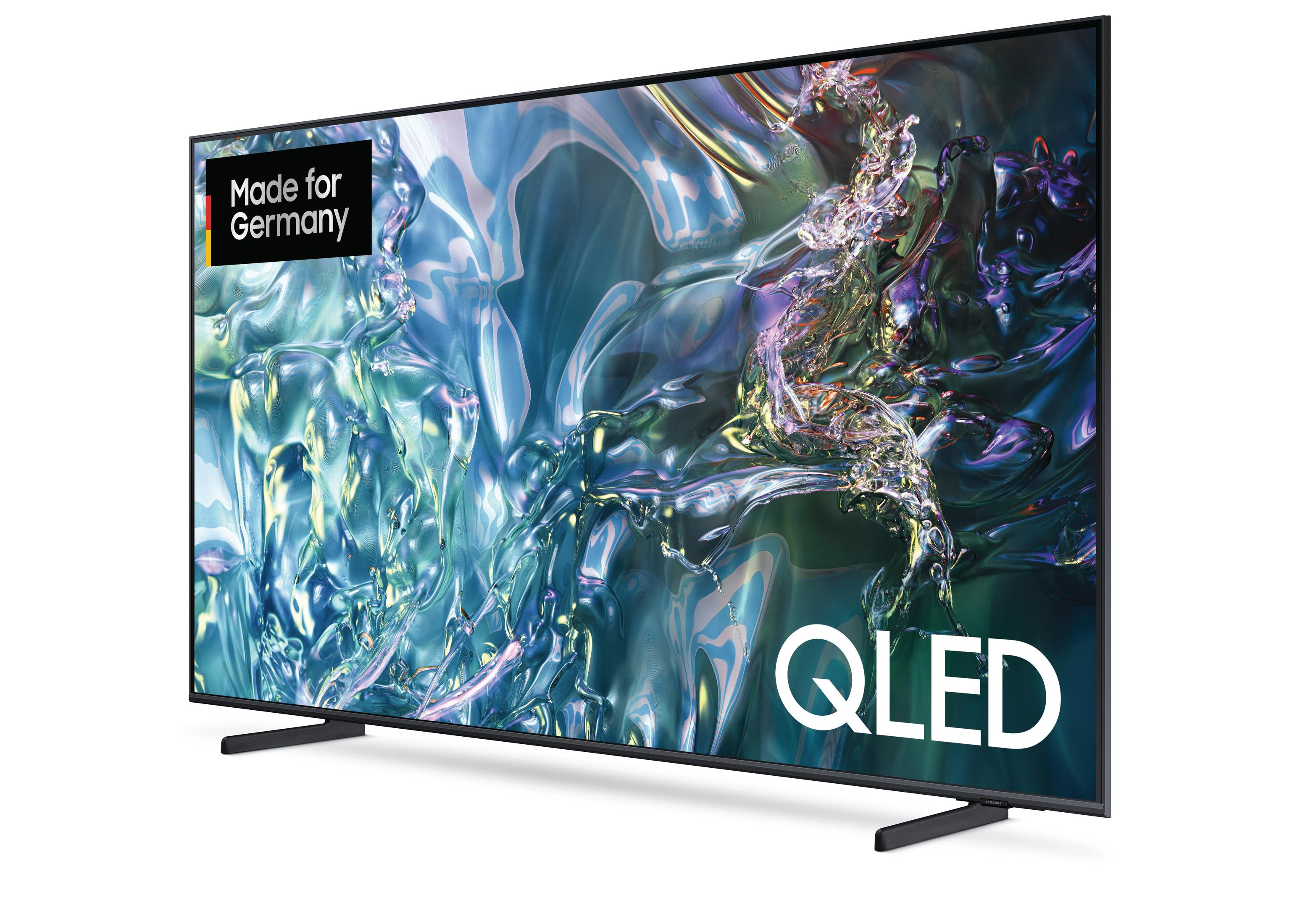 Duży telewizor QLED, czarna ramka, na białym tle. Tekst Made for Germany w lewym górnym rogu.