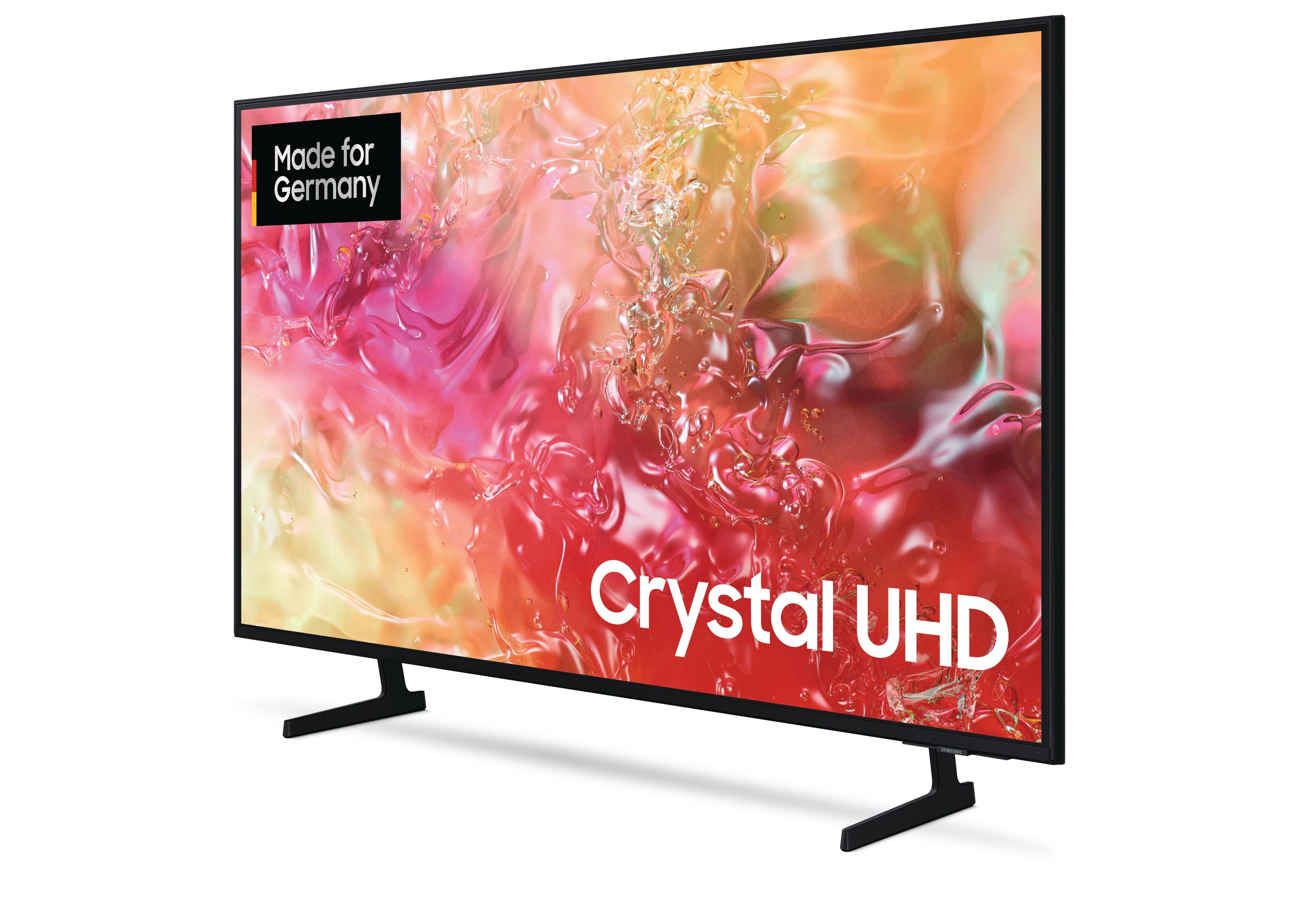 Duży, nowoczesny telewizor z czarną ramką. Tekst na ekranie brzmi 'Crystal UHD'.