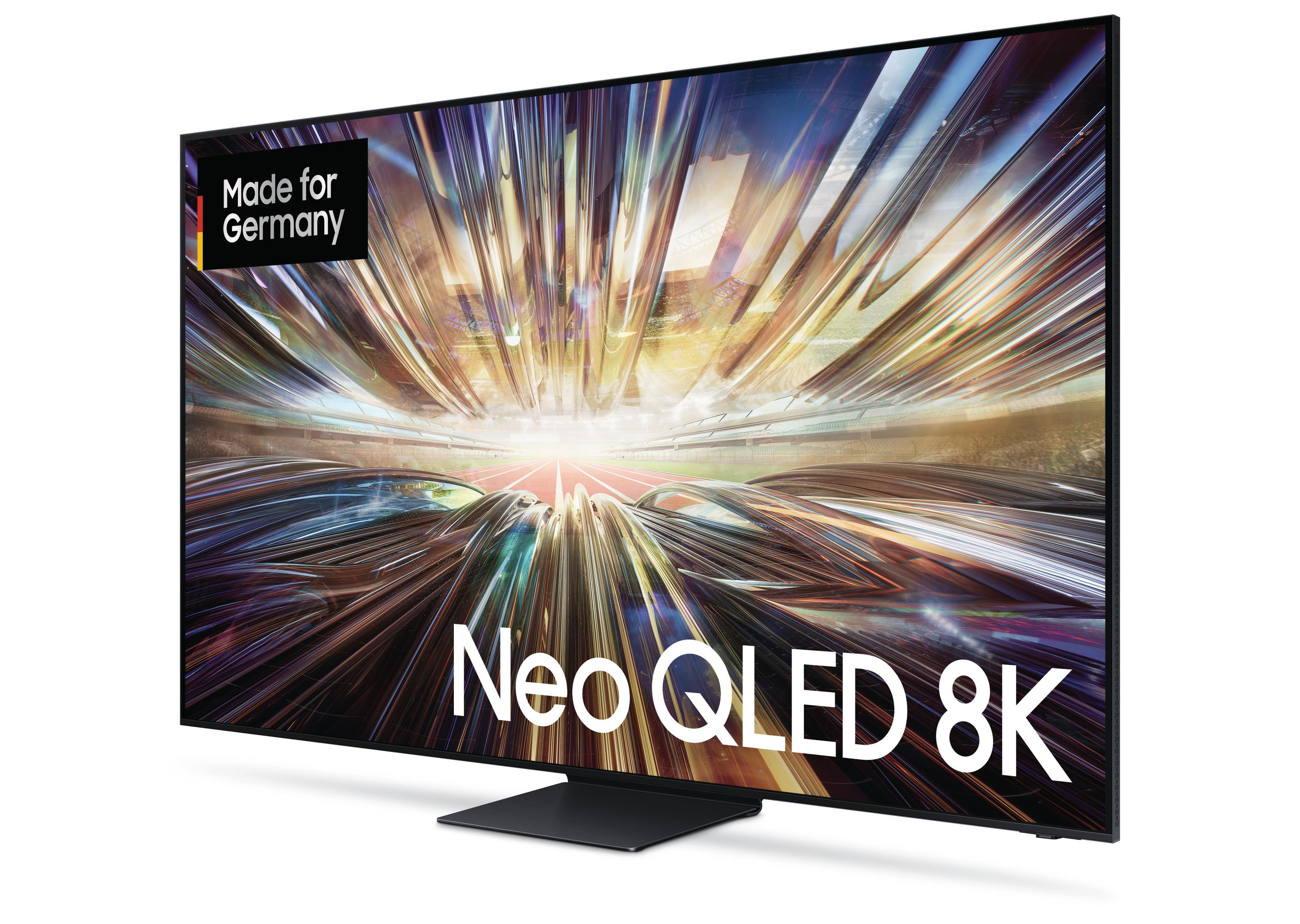Duży telewizor Neo QLED 8K z czarną ramką, widok pod kątem, z naklejką 'Made for Germany'.