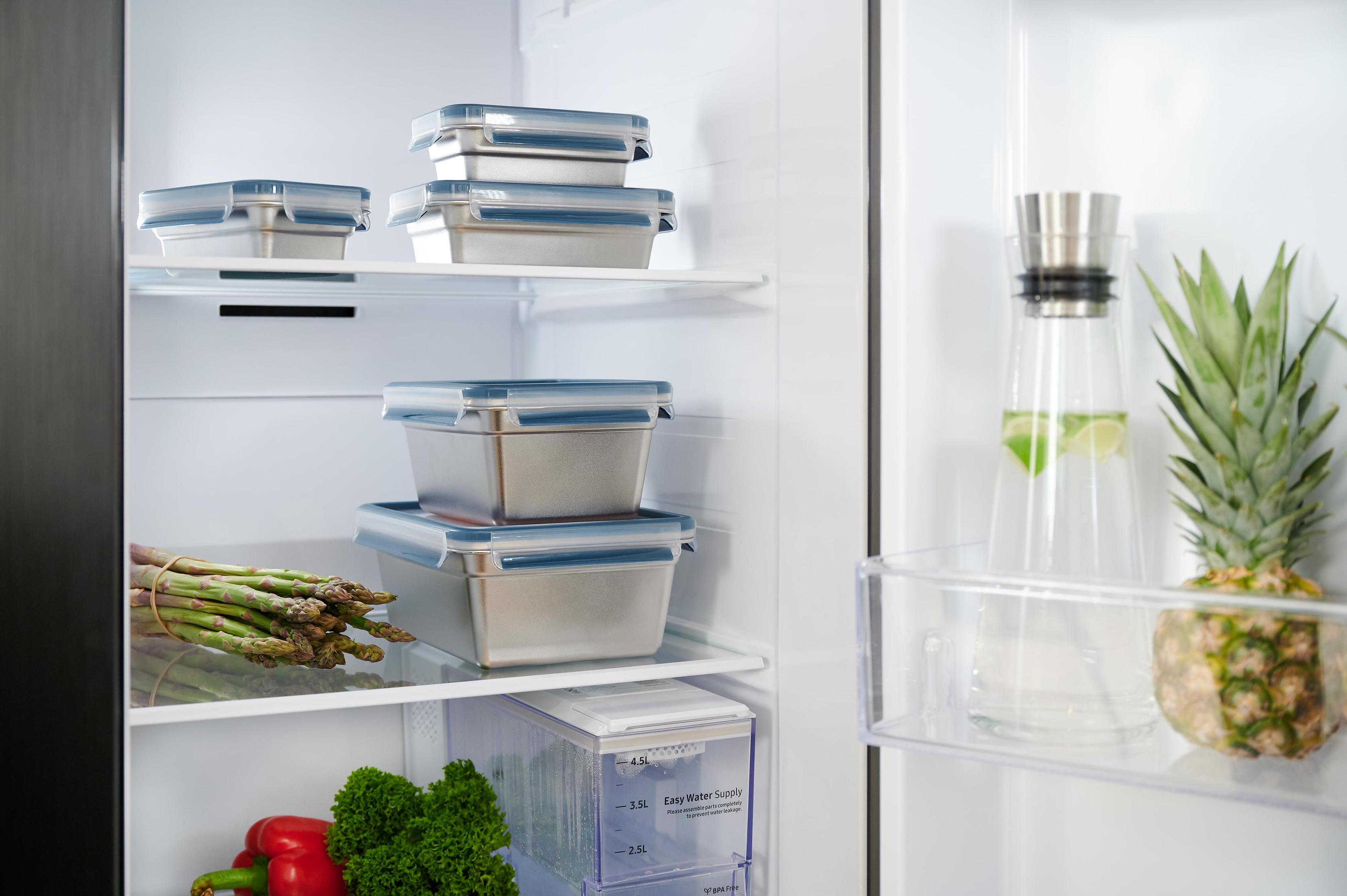 Kühlschrank mit Behältern, Spargel und Ananas.