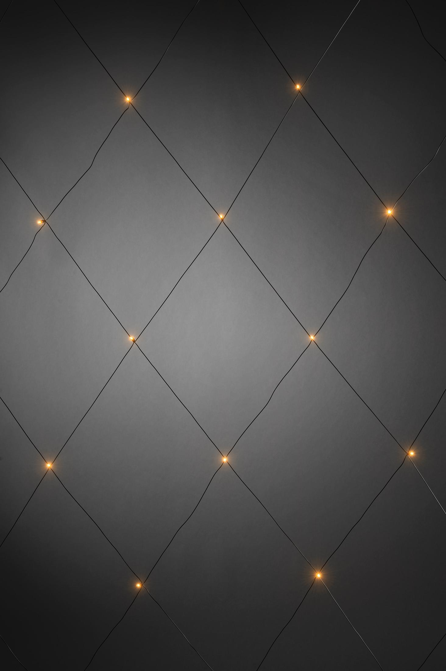 Ein dunkelgrauer Hintergrund mit einem Gitter aus kleinen, gelben Lichtern, die ein Rautenmuster bilden.