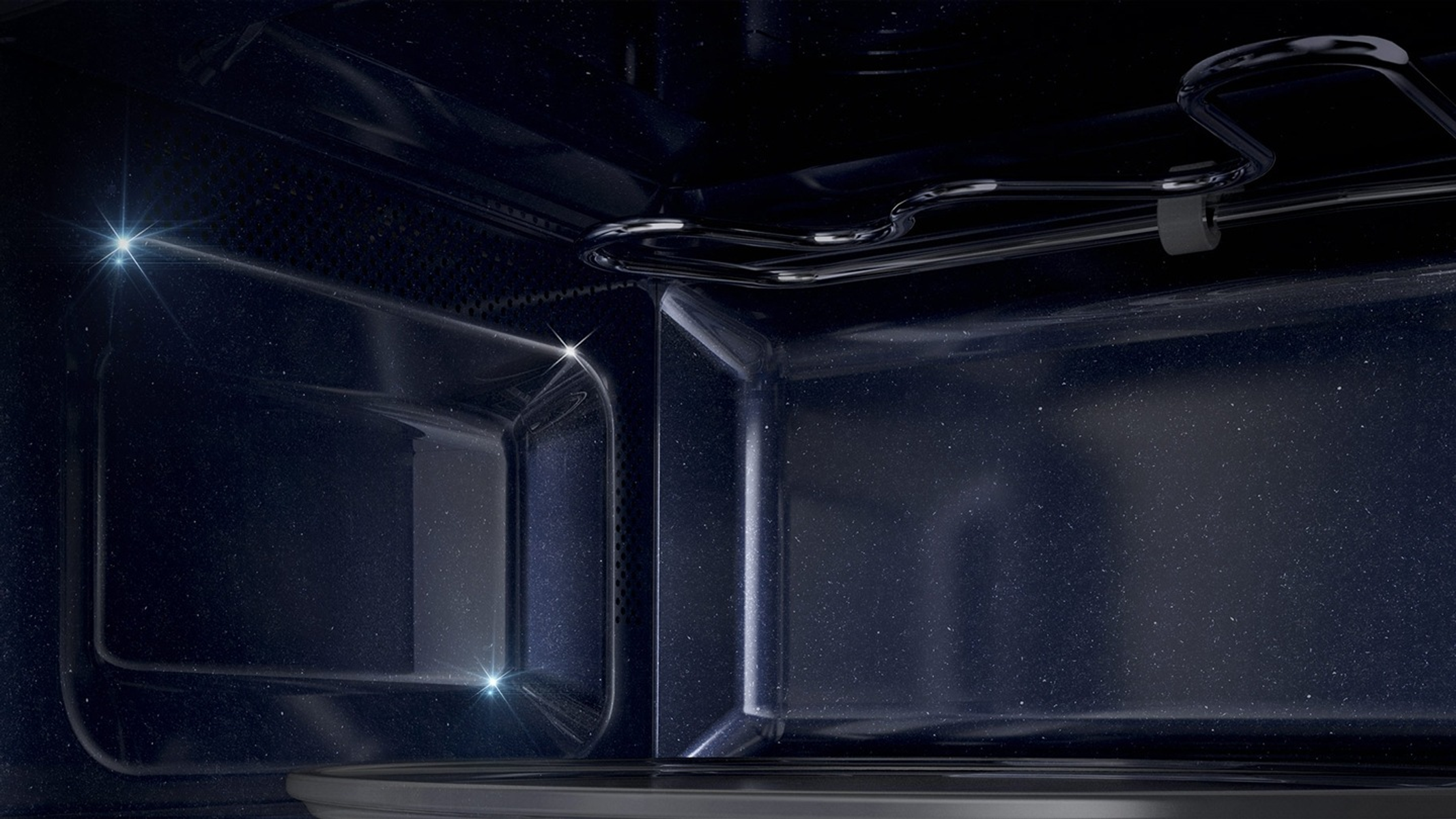 Interno di un forno a microonde, che mostra l'interno con un telaio metallico e tre luci luminose.
