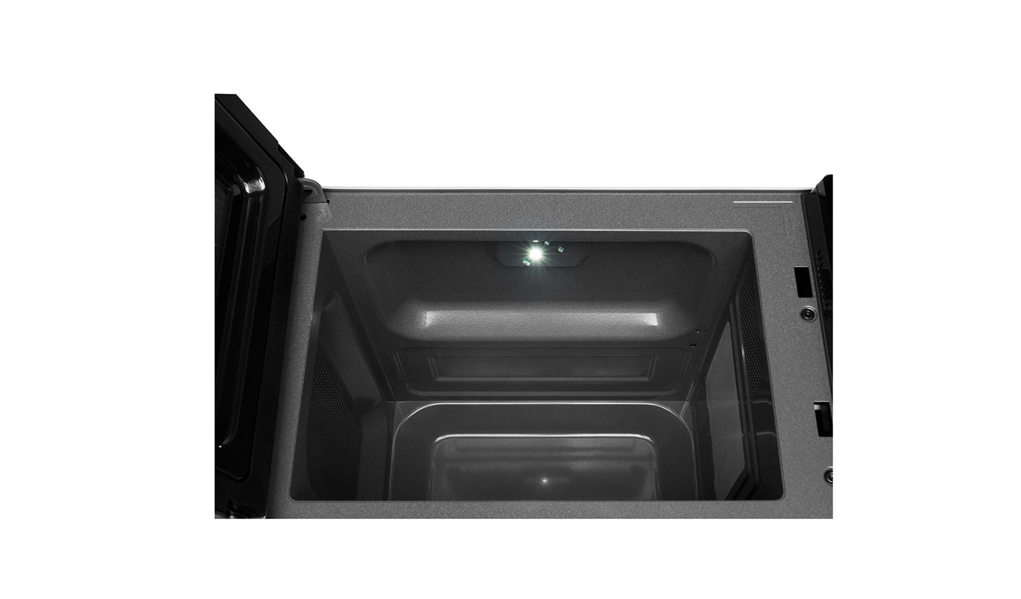 Interno di un forno a microonde, aperto, con la luce accesa.