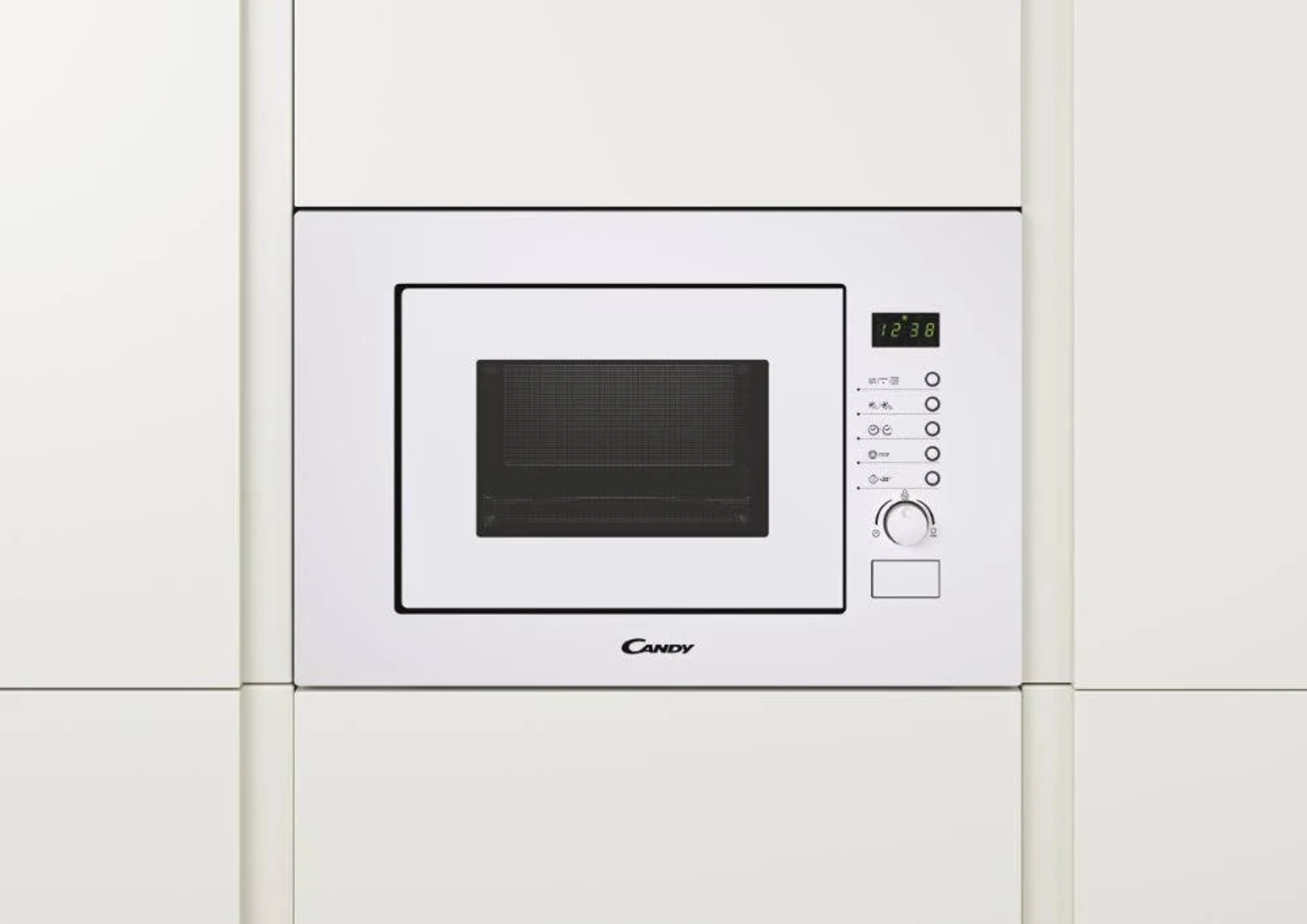 Un forno a microonde CANDY bianco integrato in armadi bianchi. Il display mostra 12:38.