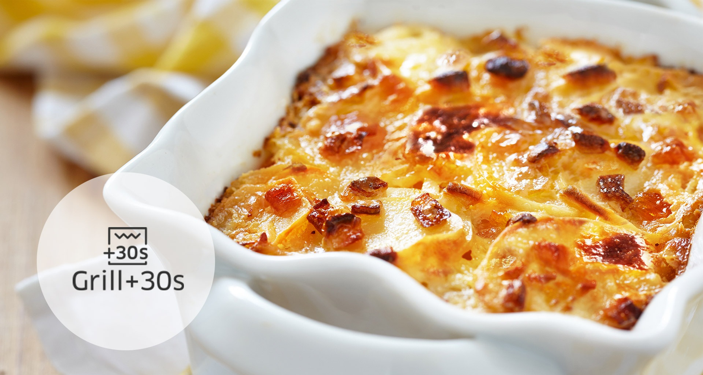 Primo piano di un piatto al forno con formaggio fuso e patate.
