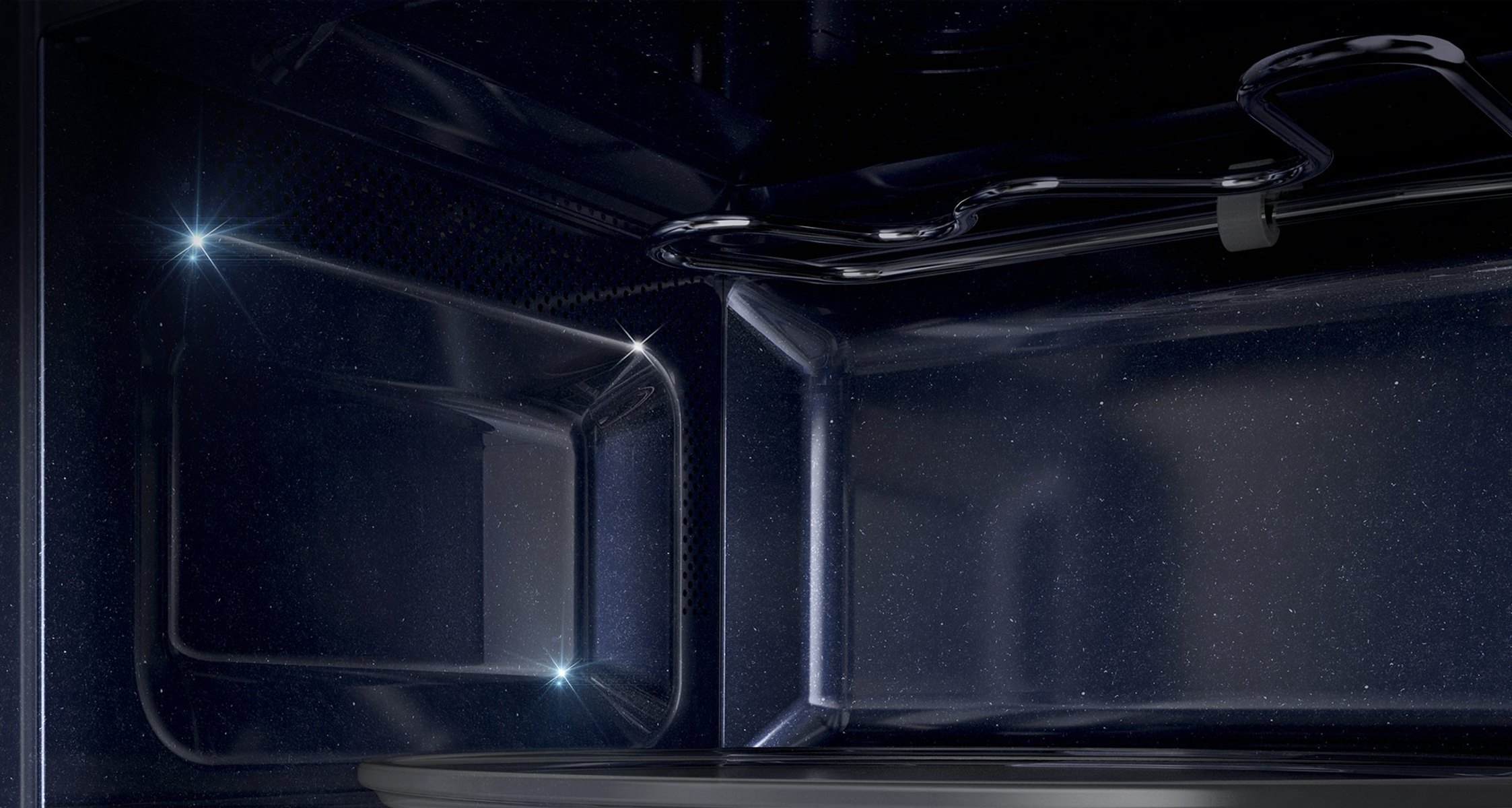 Interno di un forno a microonde con luci e componenti metallici.