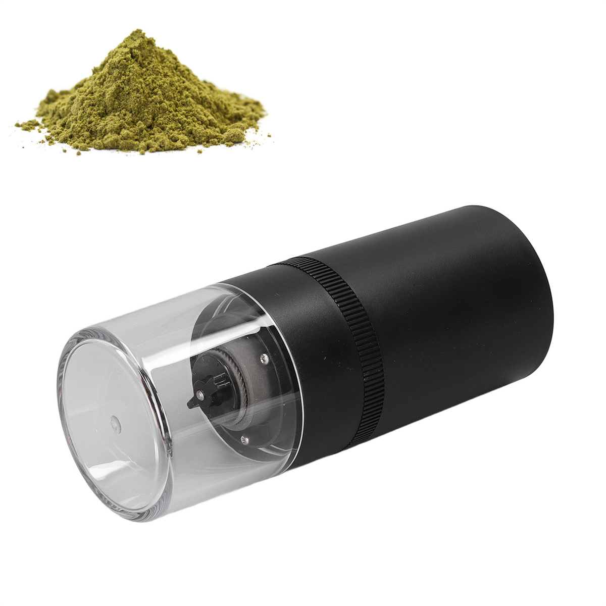 Schwarzer elektrischer Grinder und ein Haufen grüner Kräuter im Hintergrund.