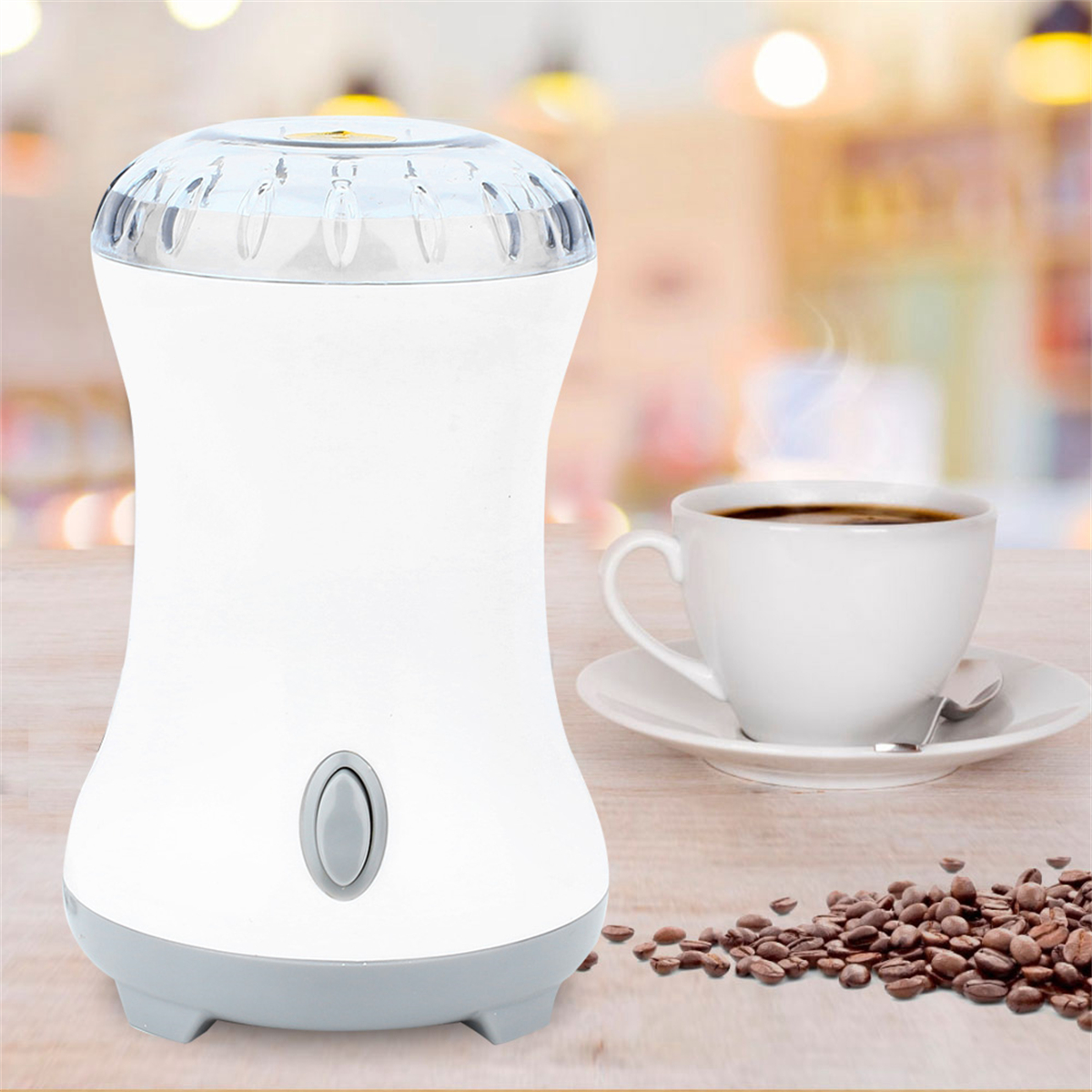 Weiße Kaffeemühle mit einer Tasse Kaffee und Kaffeebohnen.