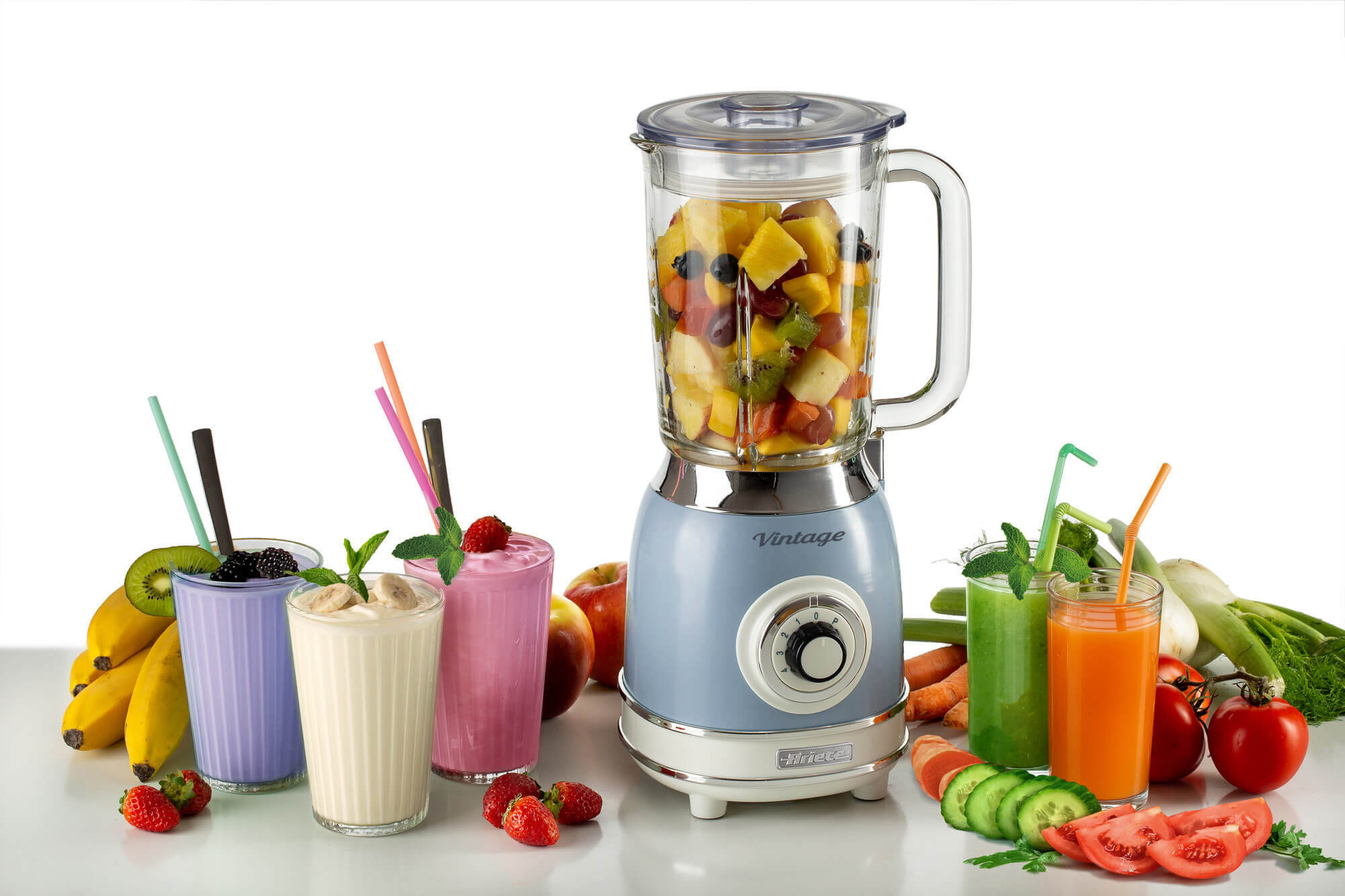 Blender met fruit erin en verschillende smoothies eromheen op tafel. Vintage design.