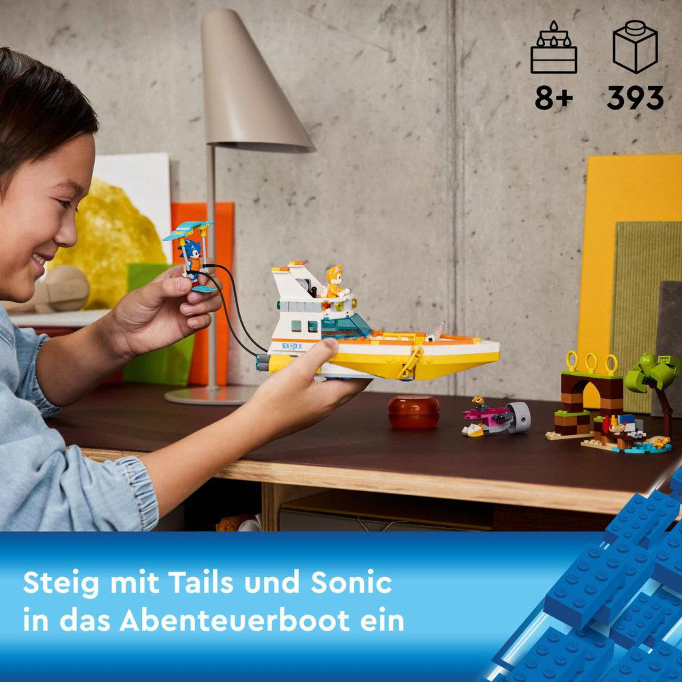 Ein Kind spielt mit einem Spielzeugboot mit Sonic und Tails. Hintergrund: Schreibtisch, Lampe, blaue Blöcke.