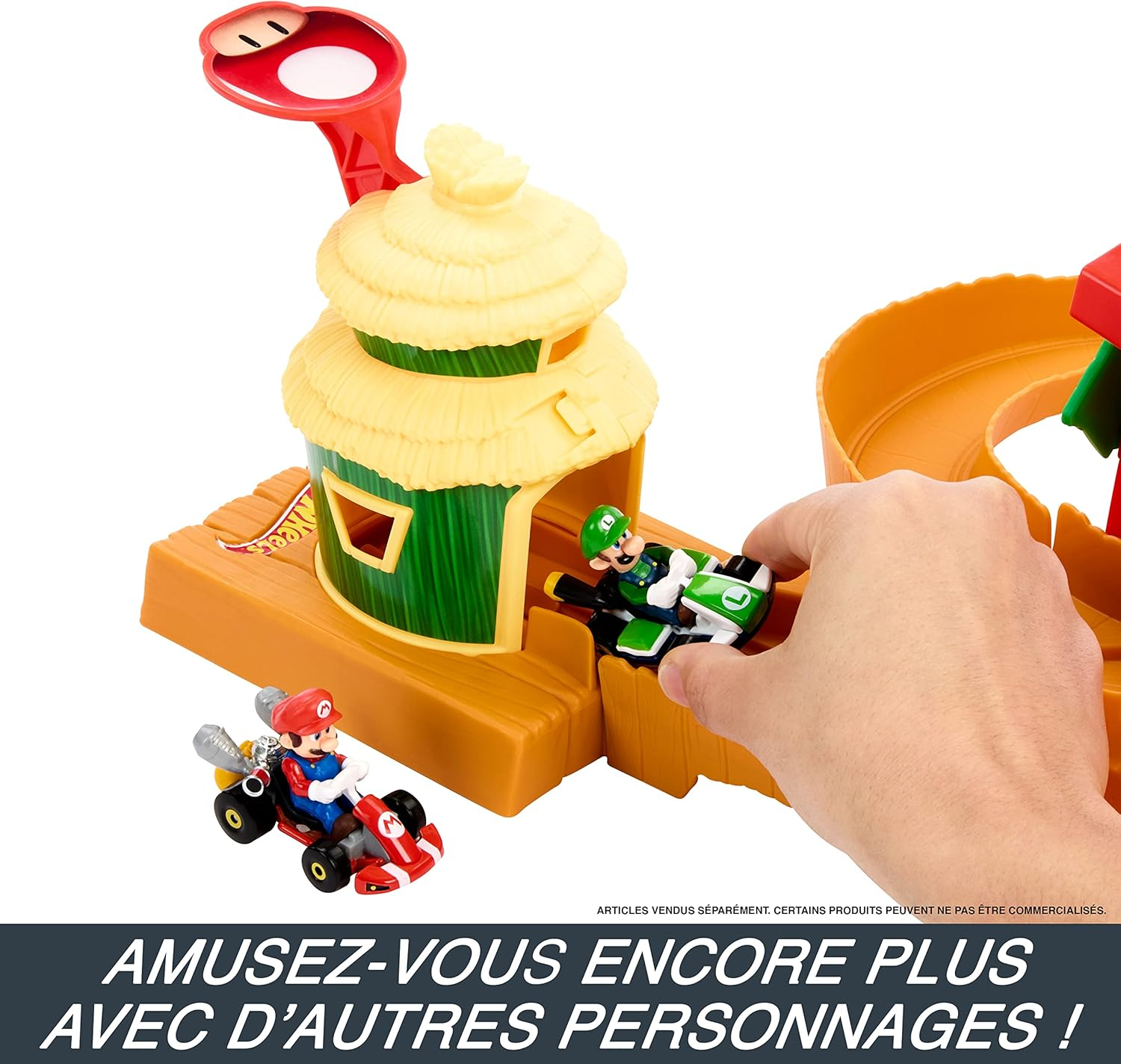 Una pista Hot Wheels con macchinine, Mario e Luigi. Una mano si avvicina. Colori vivaci.