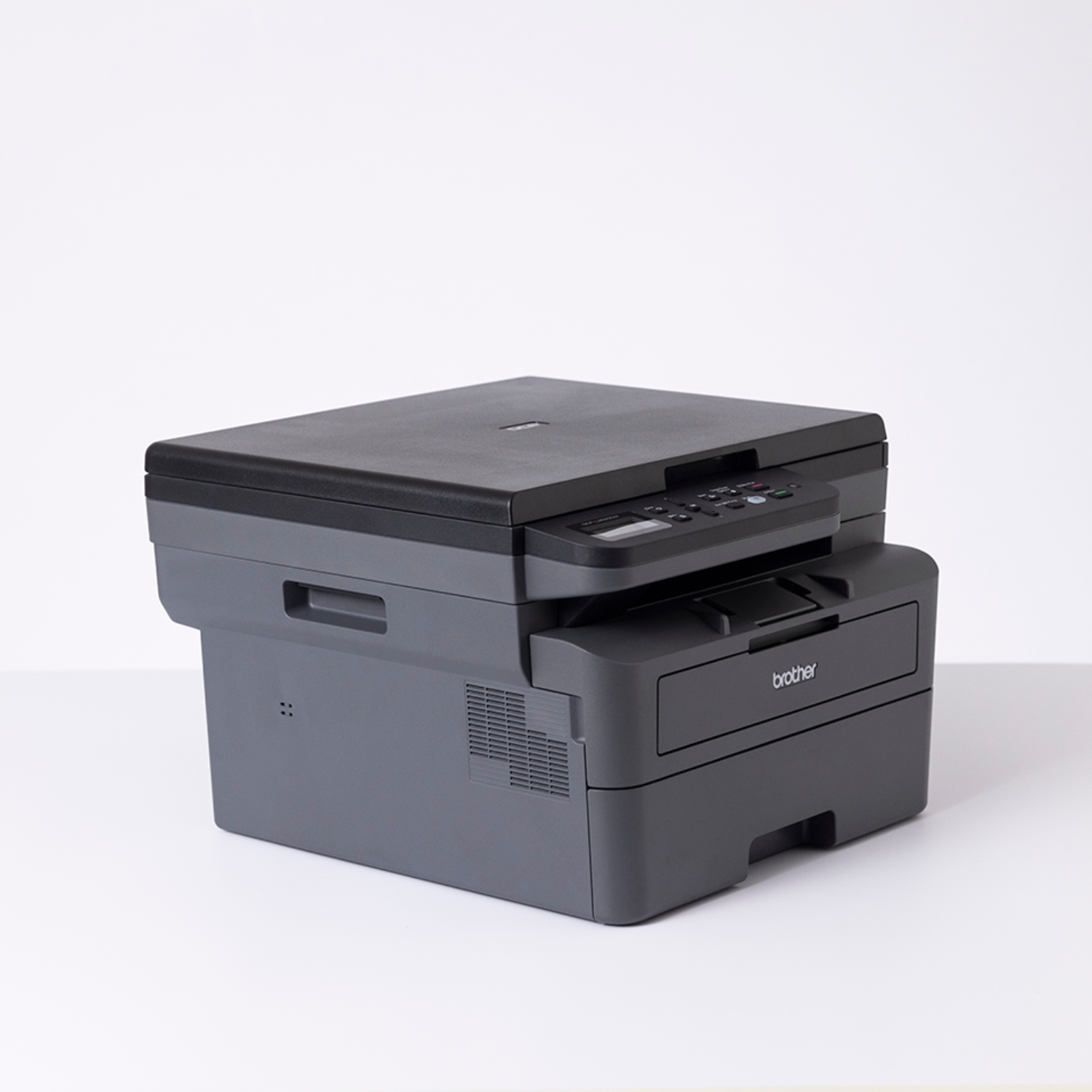 Czarno-szara drukarka Brother, widok z góry, na białej powierzchni.