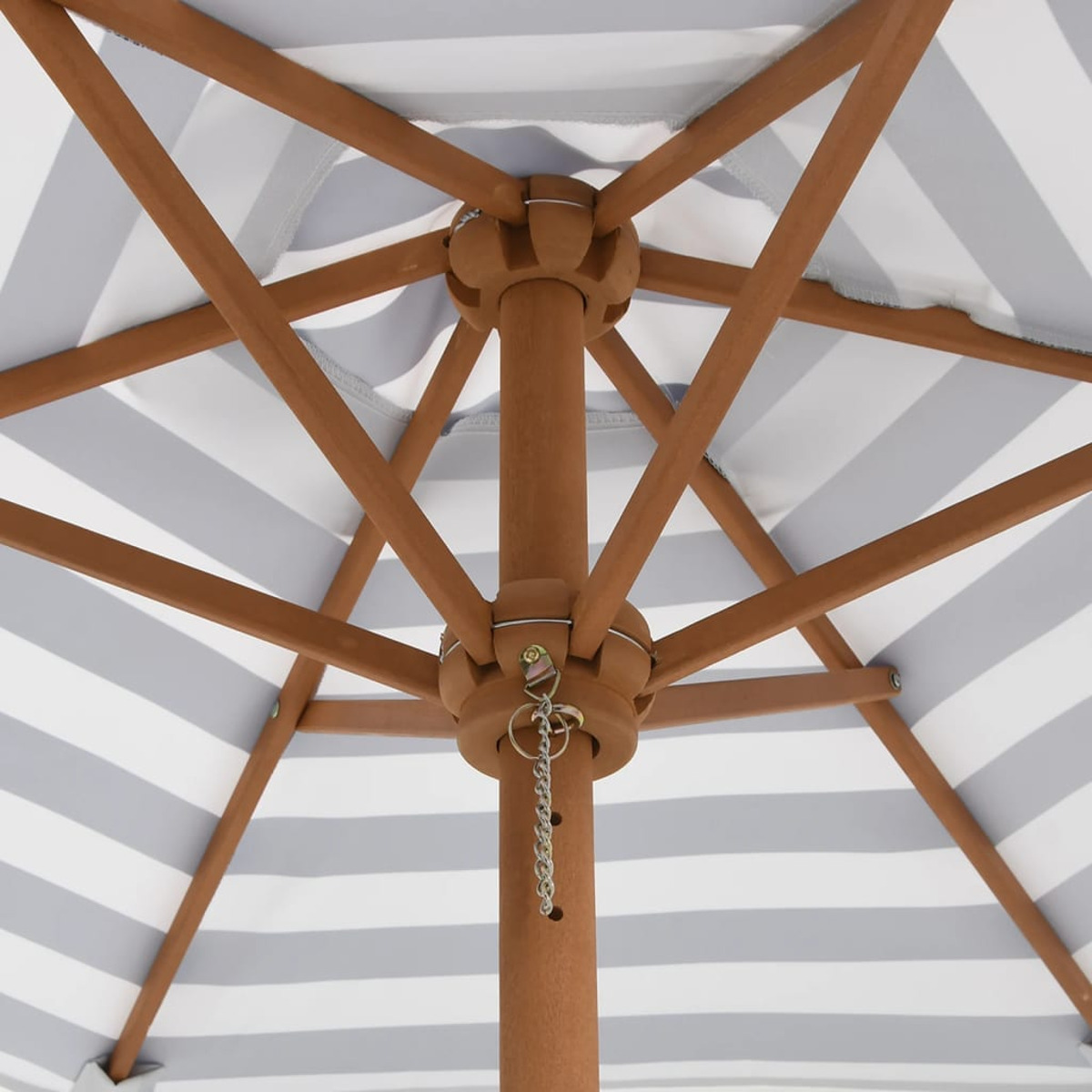 Sotto un ombrello a strisce. Struttura in legno marrone con palo centrale. Sfondo bianco.