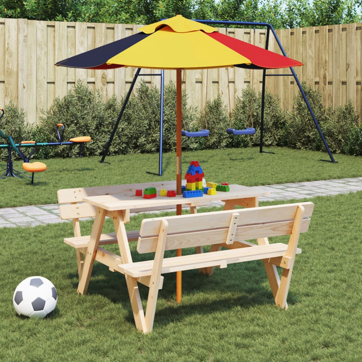Un tavolo da picnic in legno con panche, un ombrellone e un pallone da calcio sull'erba.