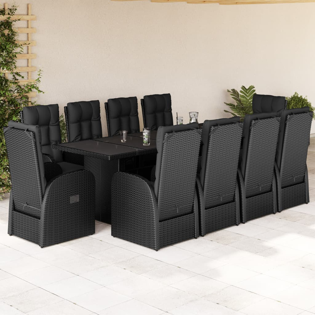Set da pranzo all'aperto con tavolo e sedie. I mobili sono in vimini nero.