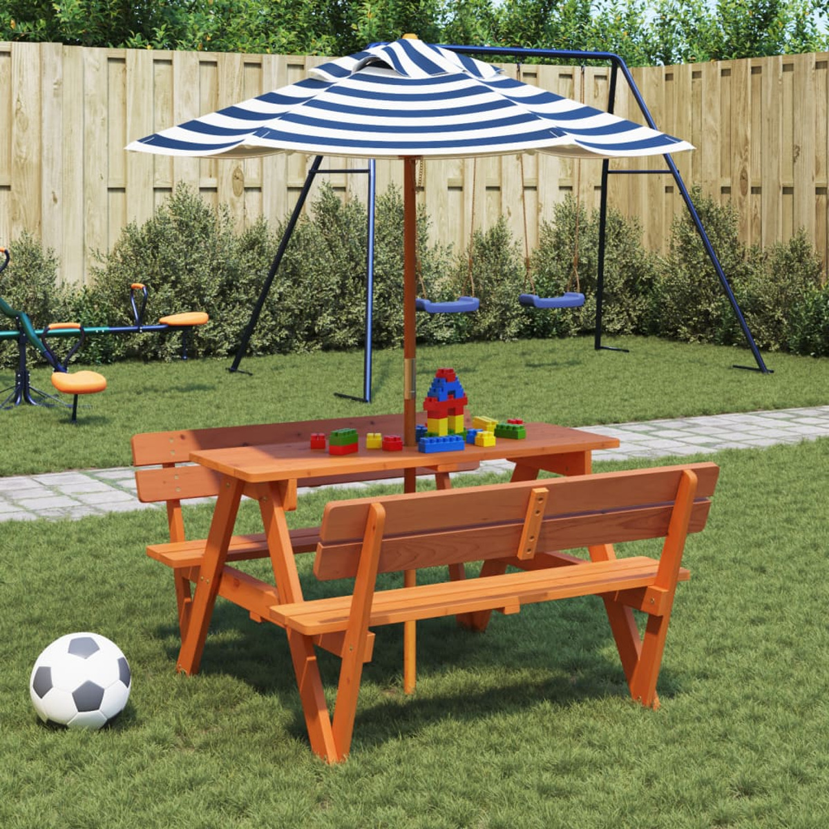 Ein Picknicktisch mit Bänken, ein Fußball und ein Spielplatz im Hintergrund.