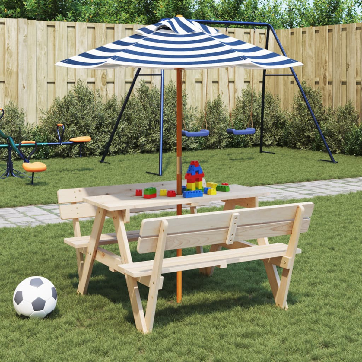 Ein Kindertisch mit Sonnenschirm, einem Fußball und Spielzeug auf dem Rasen. Im Hintergrund eine Schaukel.