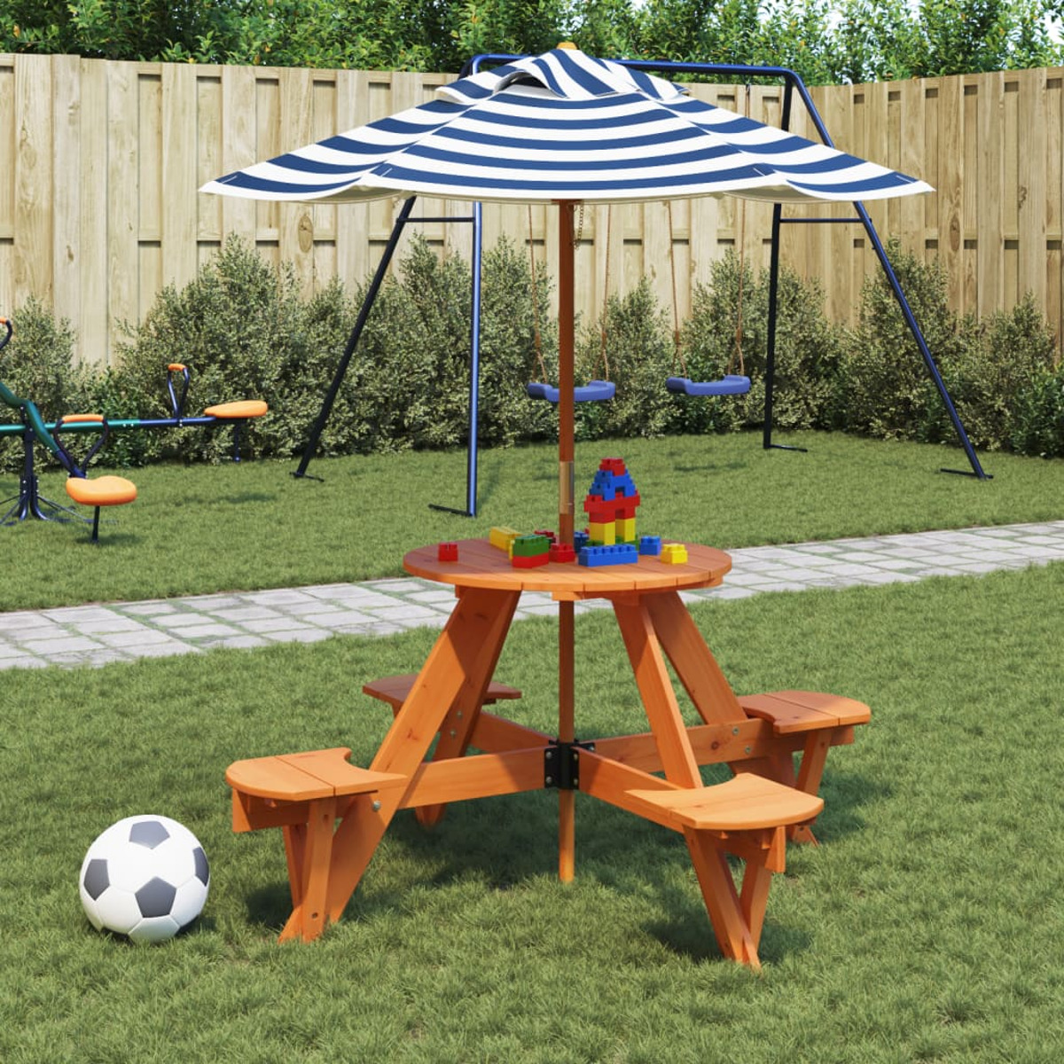 Ein Picknicktisch mit gestreiftem Sonnenschirm, Spielzeug und einem Fußball in einem grasbewachsenen Garten mit Schaukel.