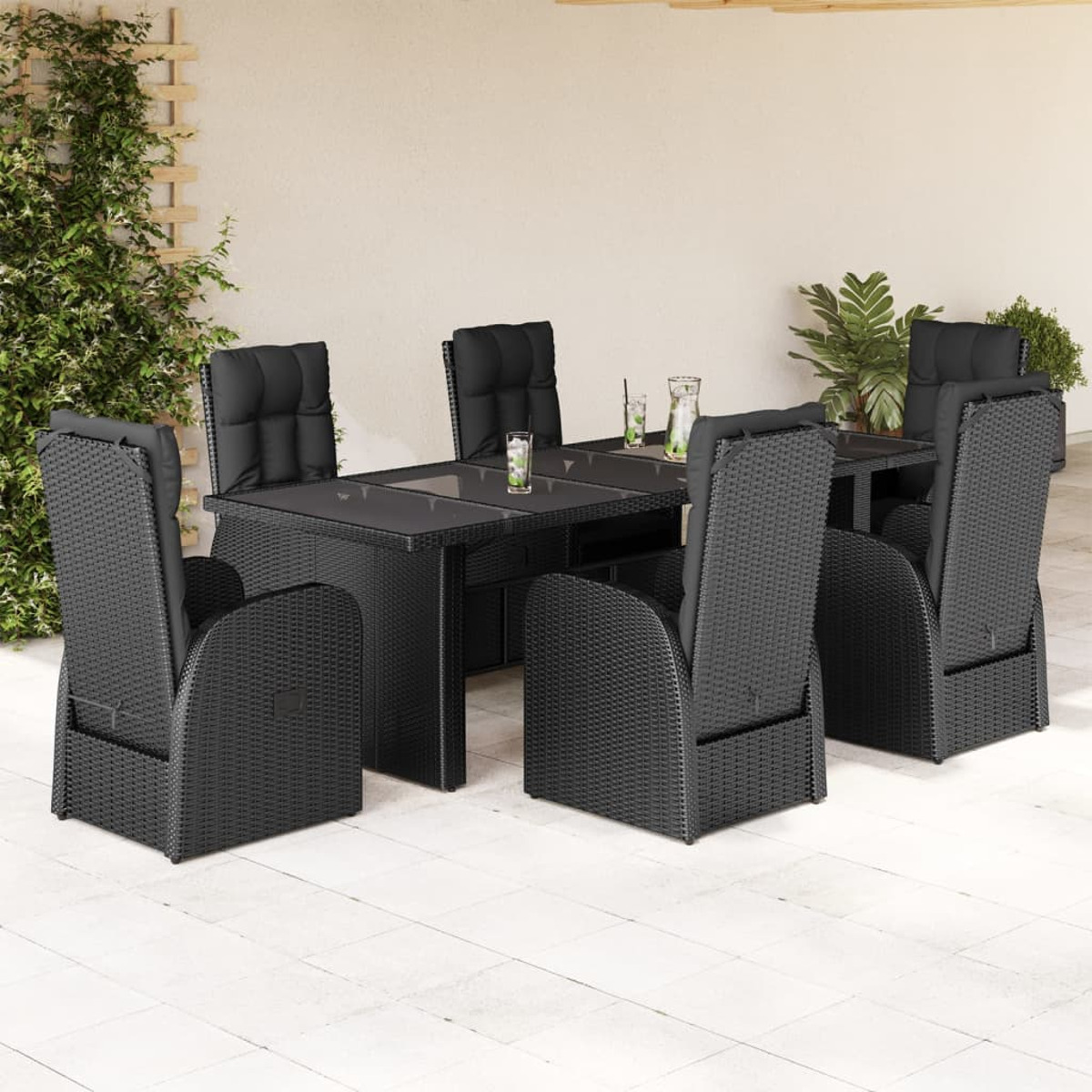 Set da pranzo da esterno in rattan nero: tavolo, sei sedie con cuscini neri, su un patio.