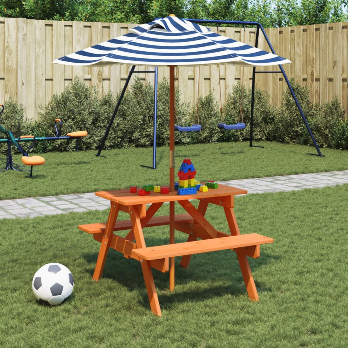 Picknicktisch und Schaukel im Garten. Ein Fußball und Spielzeug sind vorhanden.