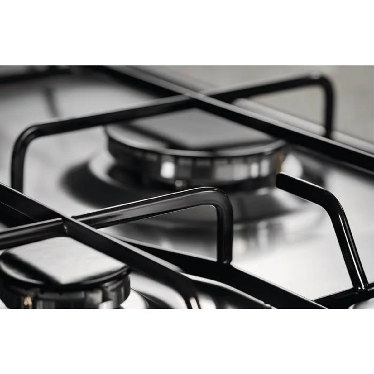 Primer plano de quemadores de estufa de gas. Rejillas negras, superficie de acero inoxidable.